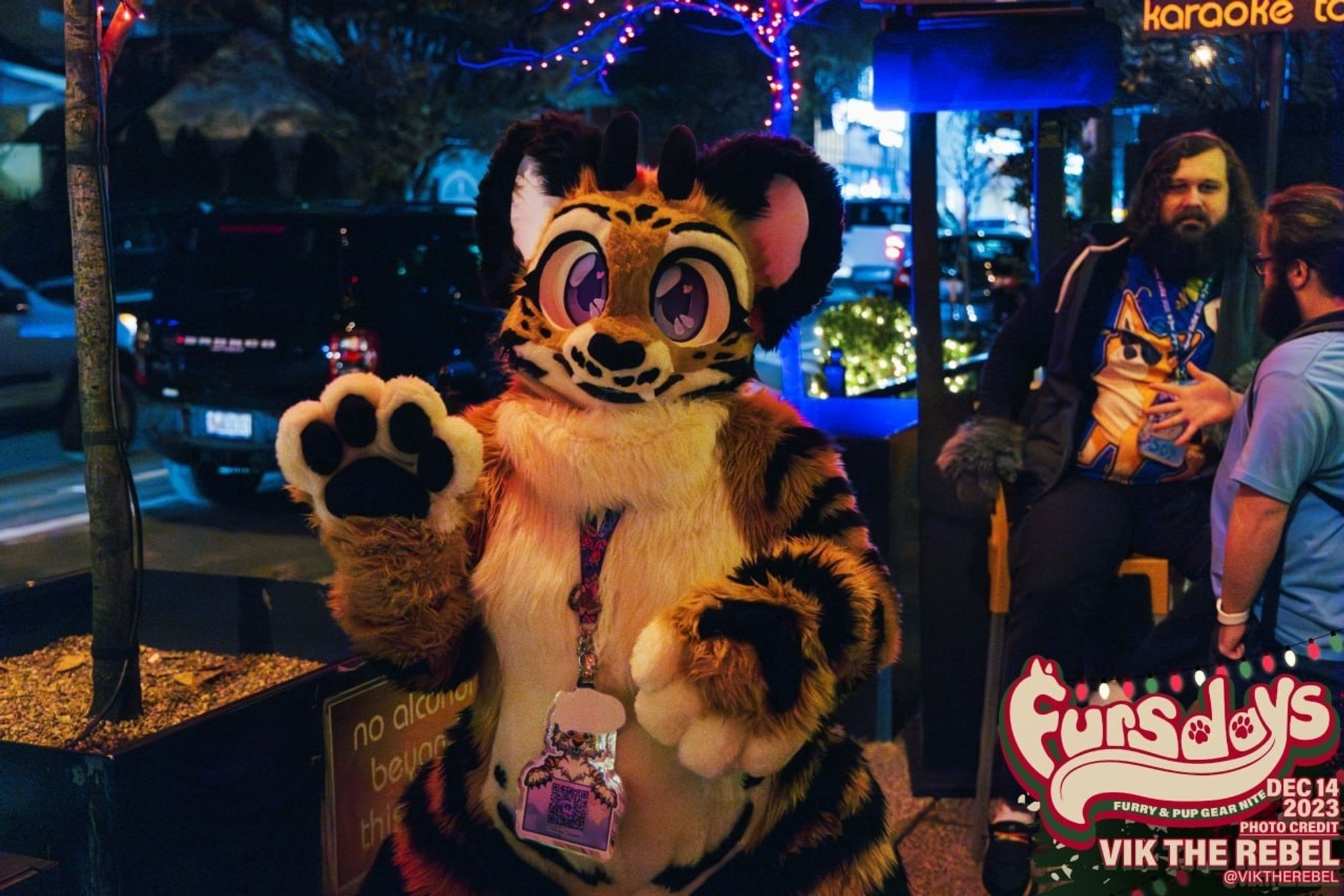 Bengal tiger part dragon fursuit waving with a patio in the background.