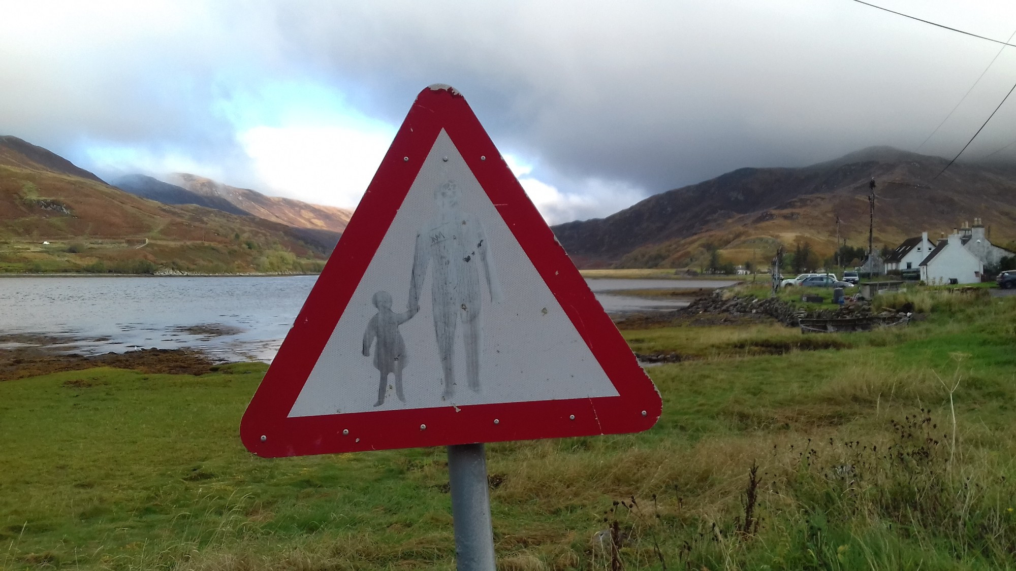 road sign showing adult and child. it's very faded. in bundalloch