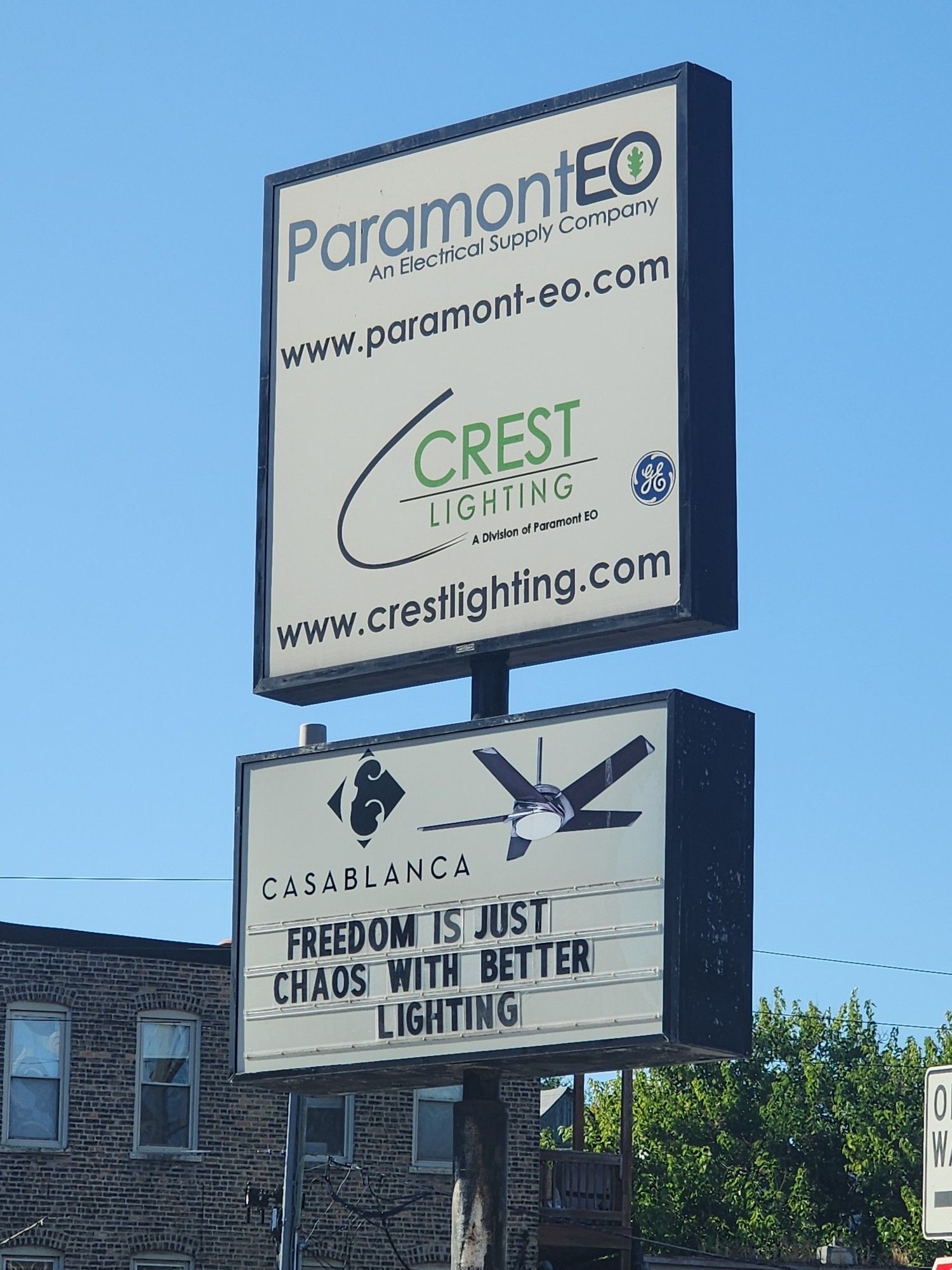 A sign for an electrical supply and service company in Chicago with a marquee that reads "Freedom is just chaos with better lighting"