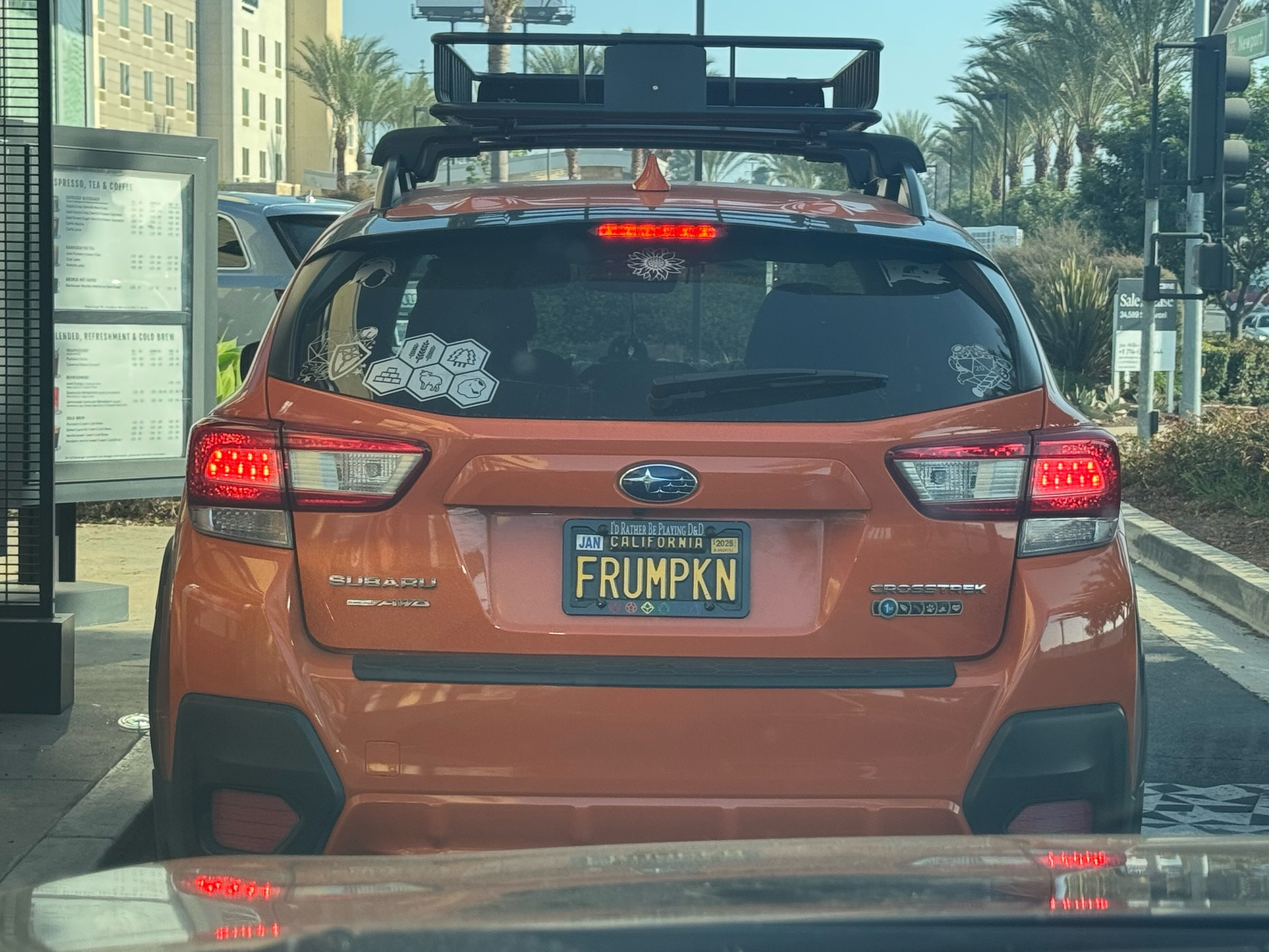 FRUMPKIN license plate on an orange Subaru outback with a bunch of dungeons and dragons stickers and stuff