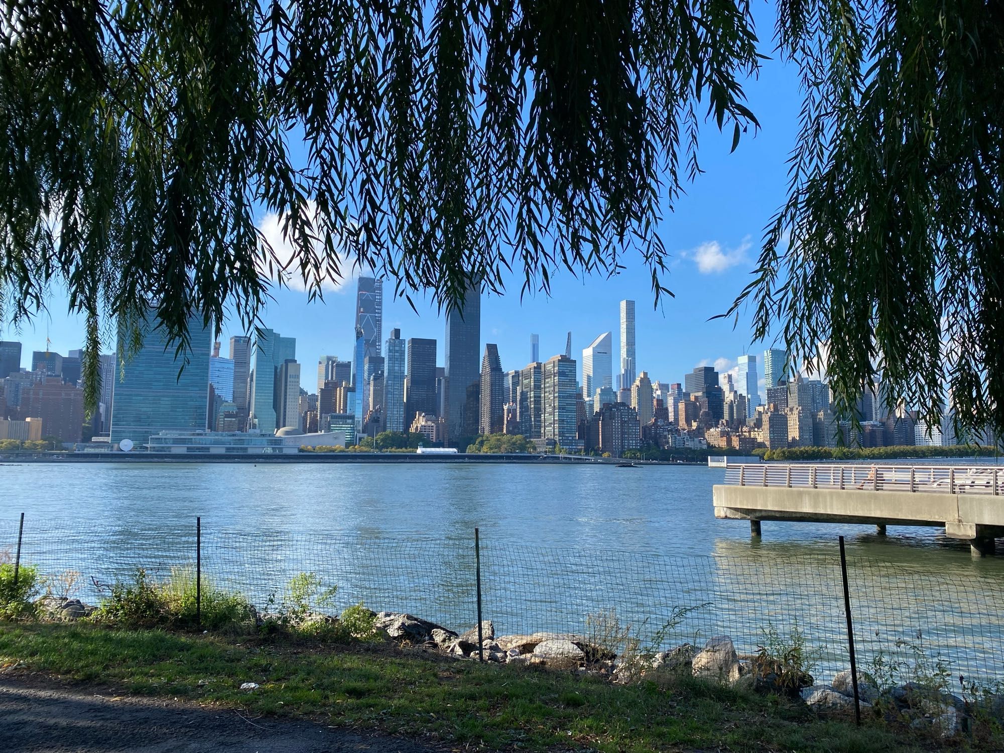 View of the East River from the LIC waterfront overlooking midtown East skyline, heliport and ferry launches.