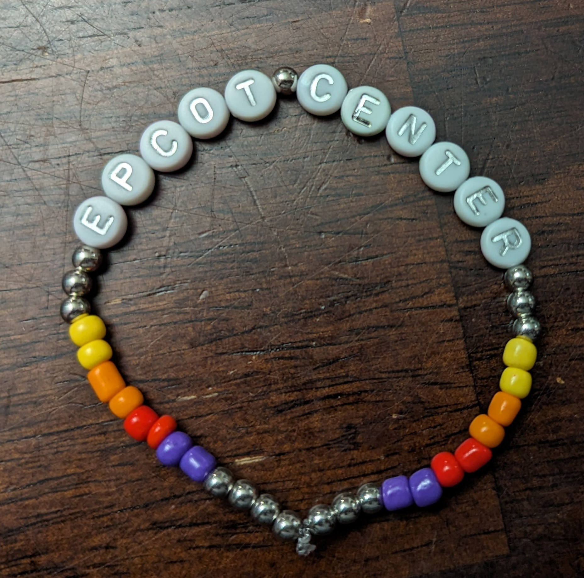 Epcot Center bracelet with silver beads rainbow patterning and the words Epcot Center