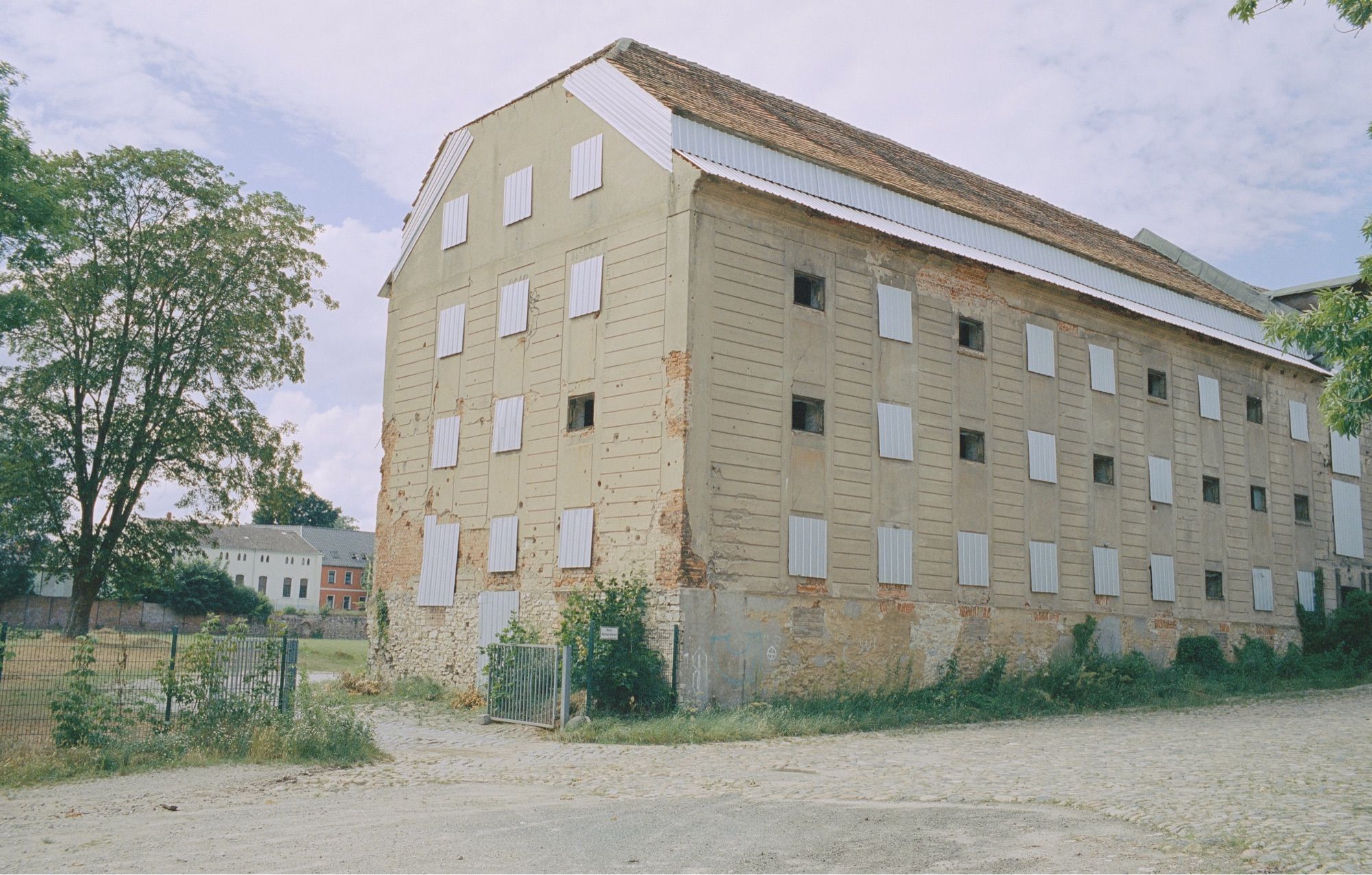 An abandoned building with open and closed windows.