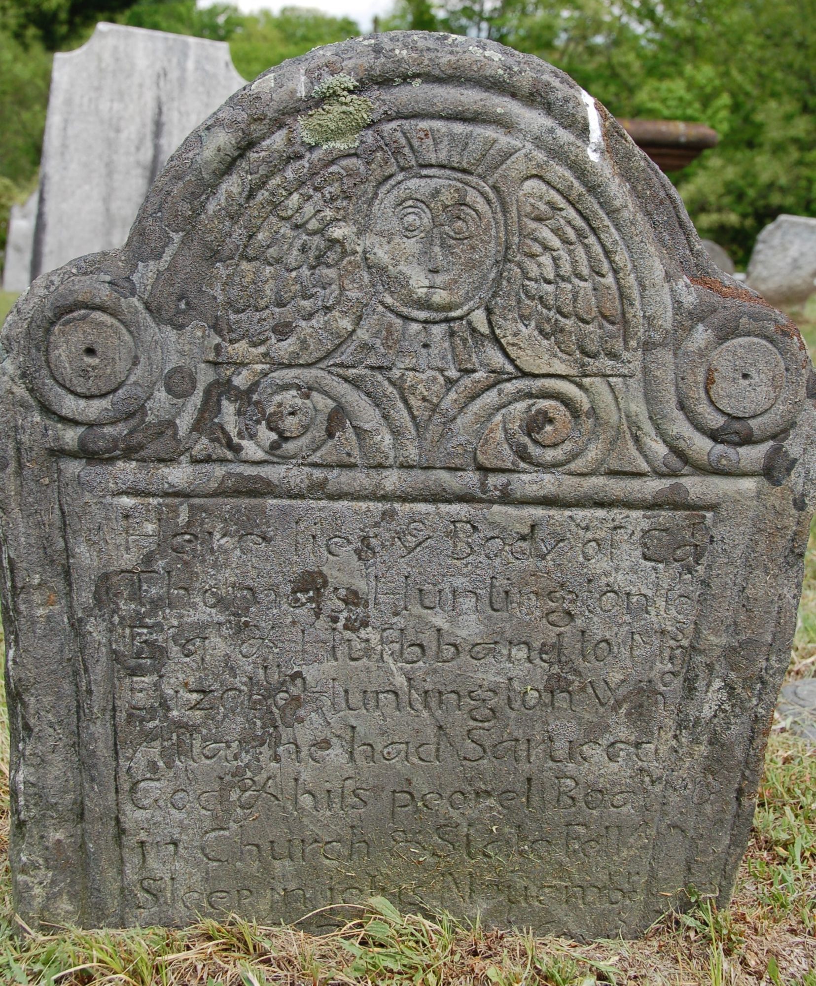 a similar gray gravestone with winged soul effigy and epitaph for "Thomas Huntington Esqr & Husbband to Mrs Elizebeth Huntington"