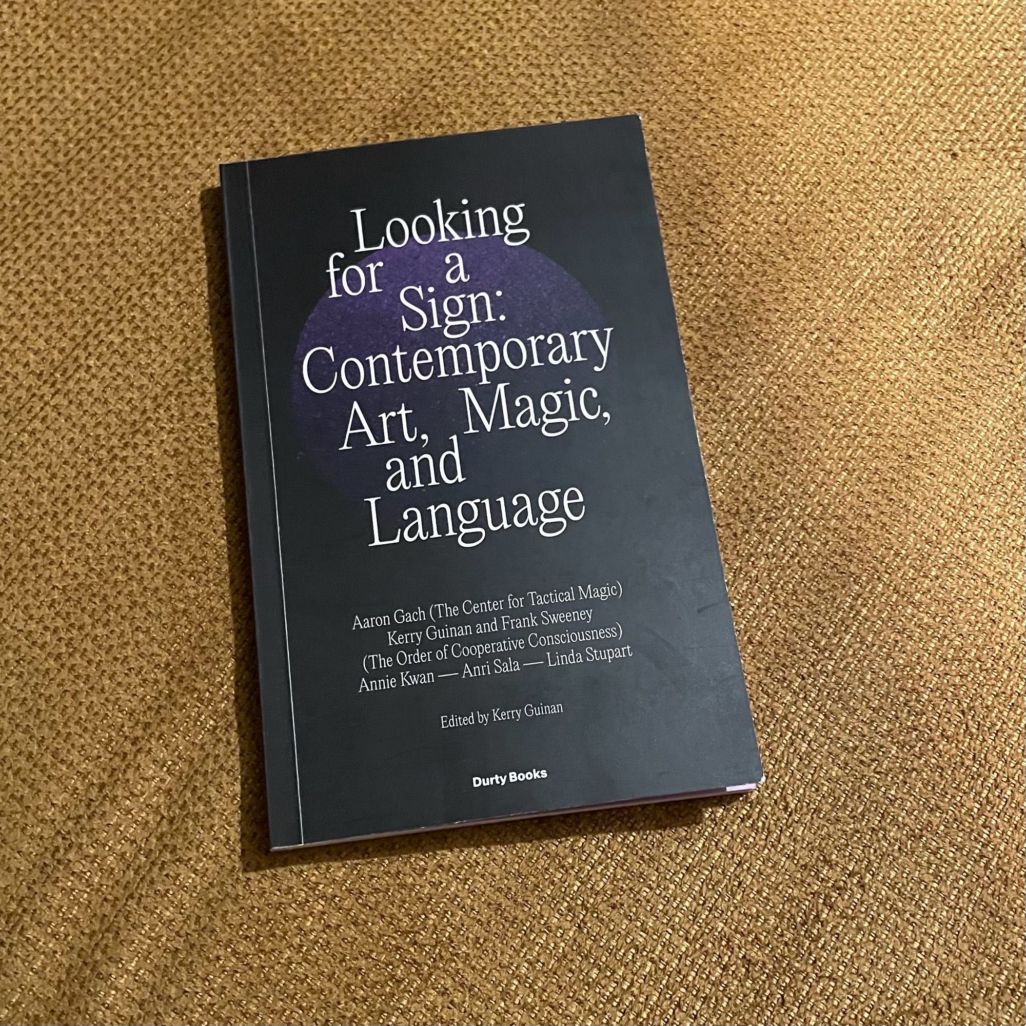 Ein schmales schwarzes Buch, darauf steht in weißen Serifen: Looking for a Sign: Contemporary Art, Magic, and Language. Aaron Gach (The Center for Tactical Magic), Kerry Guinan and Frank Sweeney, (The Order of Cooperative Consciousness)
Annie Kwan - Anri Sala - Linda Stupart
Edited by Kerry Guinan