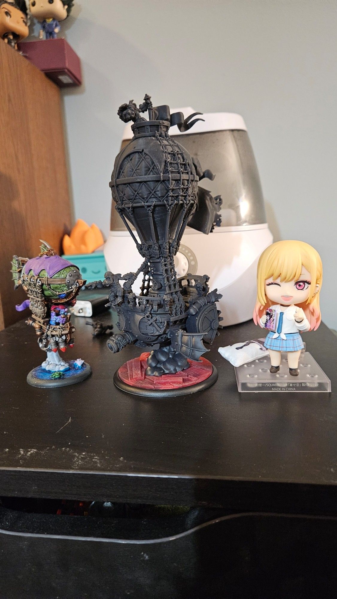 Pyg Battle Brig from Warmachine next to a Dress Up Darling nendroid.