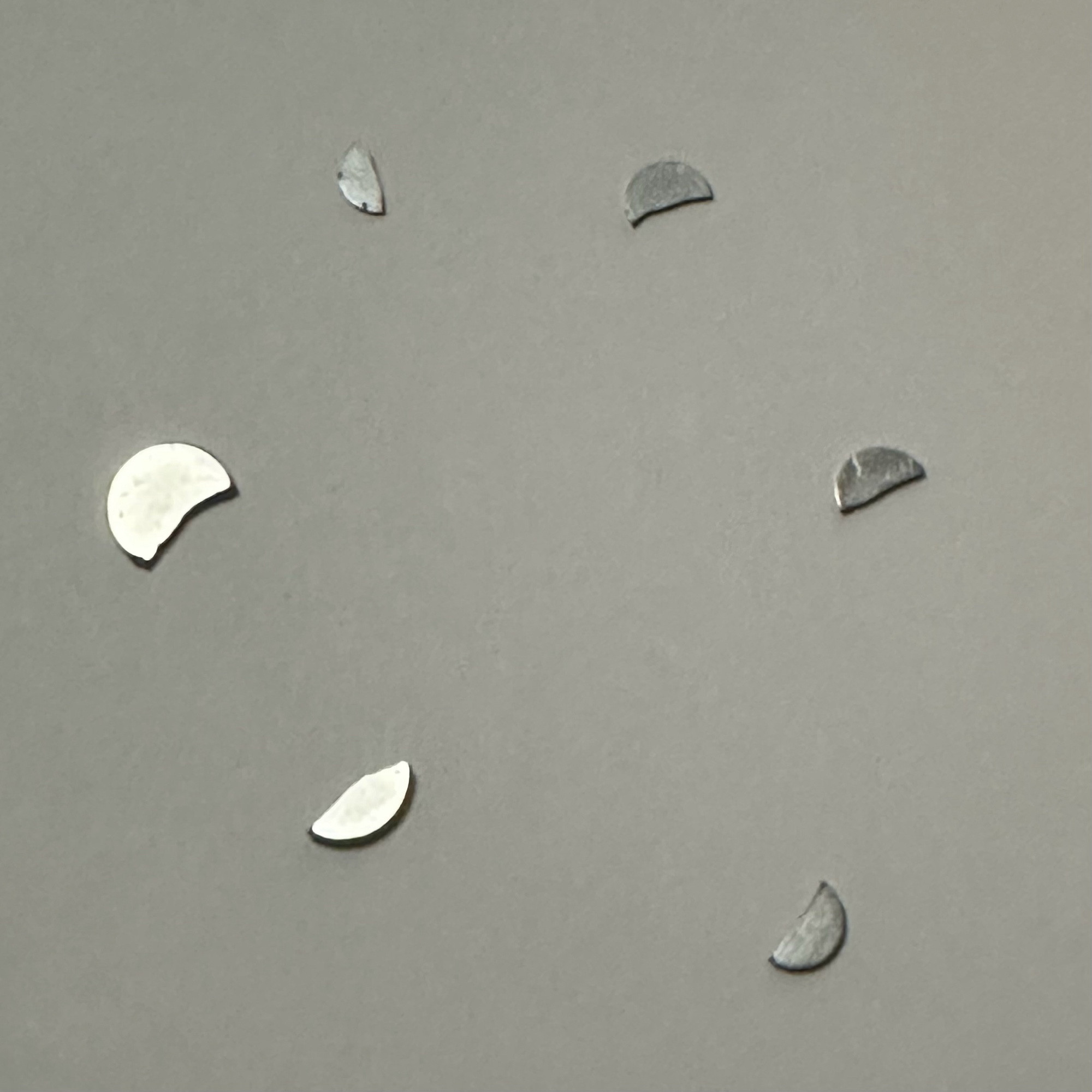 Three small, circular neodymium magnets busted up into six pieces.