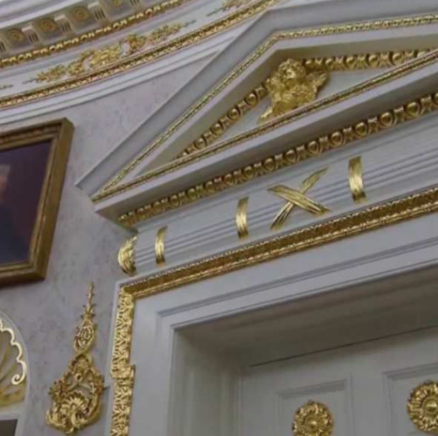 White doorway with Trump's cheap gold spray-painted filigree all over it.