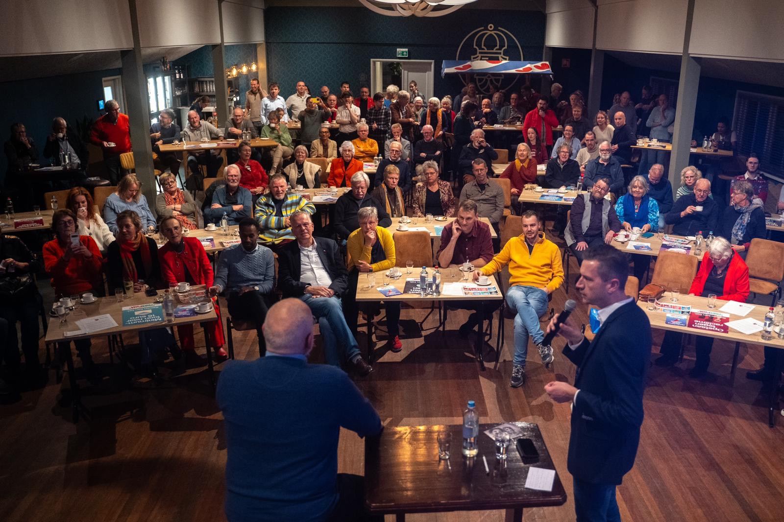 Frans Timmermans staat in een volle zaal in Heerenveen, waar hij vragen beantwoordt en mensen oproept om te gaan stemmen.