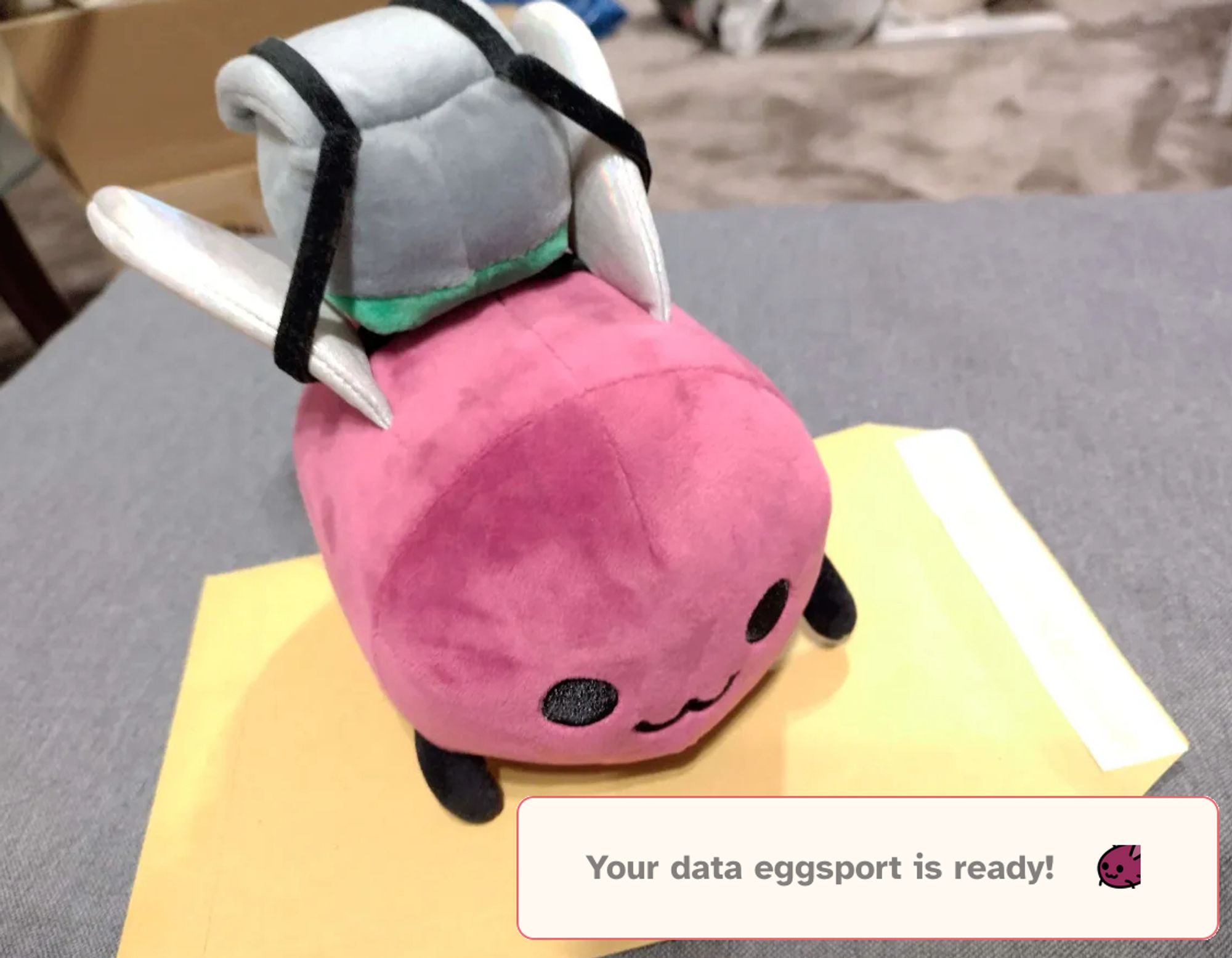 Eggbug wearing delivery backpack, holding an envelope. Caption: Your data eggsport is ready!