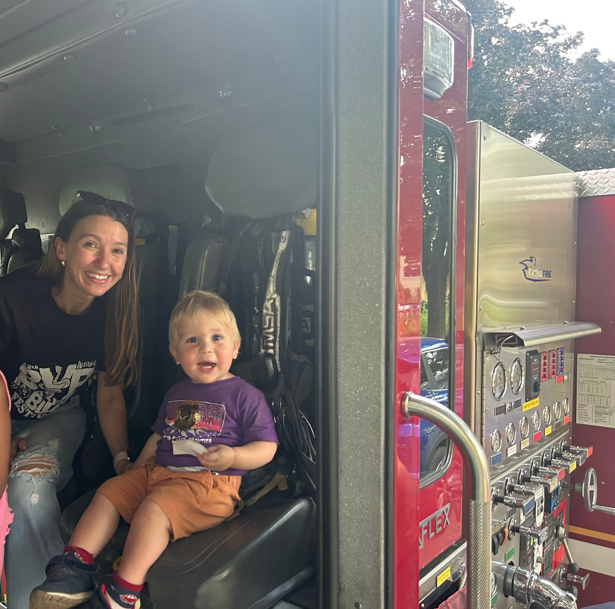Molly and toddler Leo sit in a fire truck 