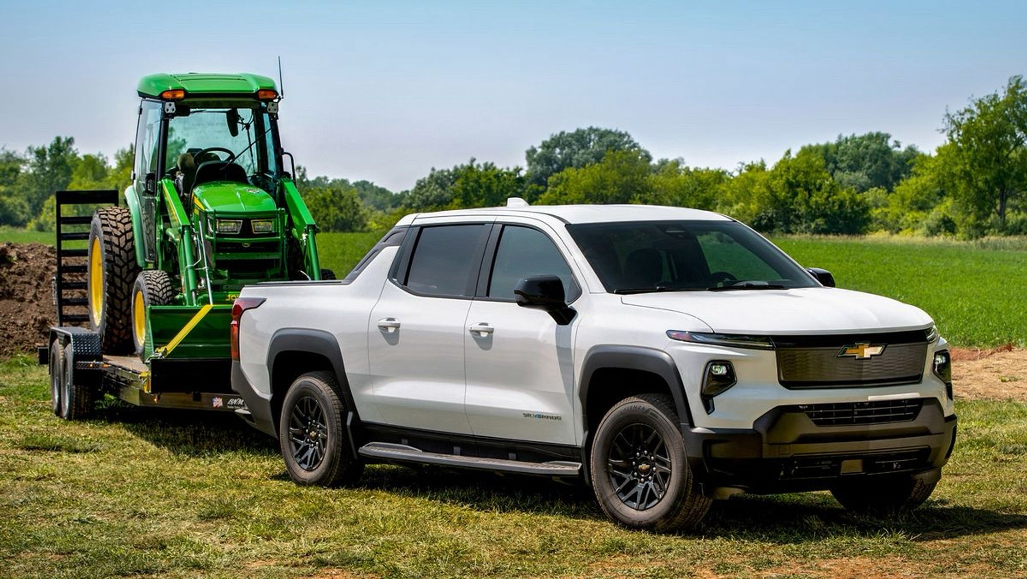 A Chevy Silverado EV with a 200-Kilowatt hour battery pack pulling a John Deere tractor