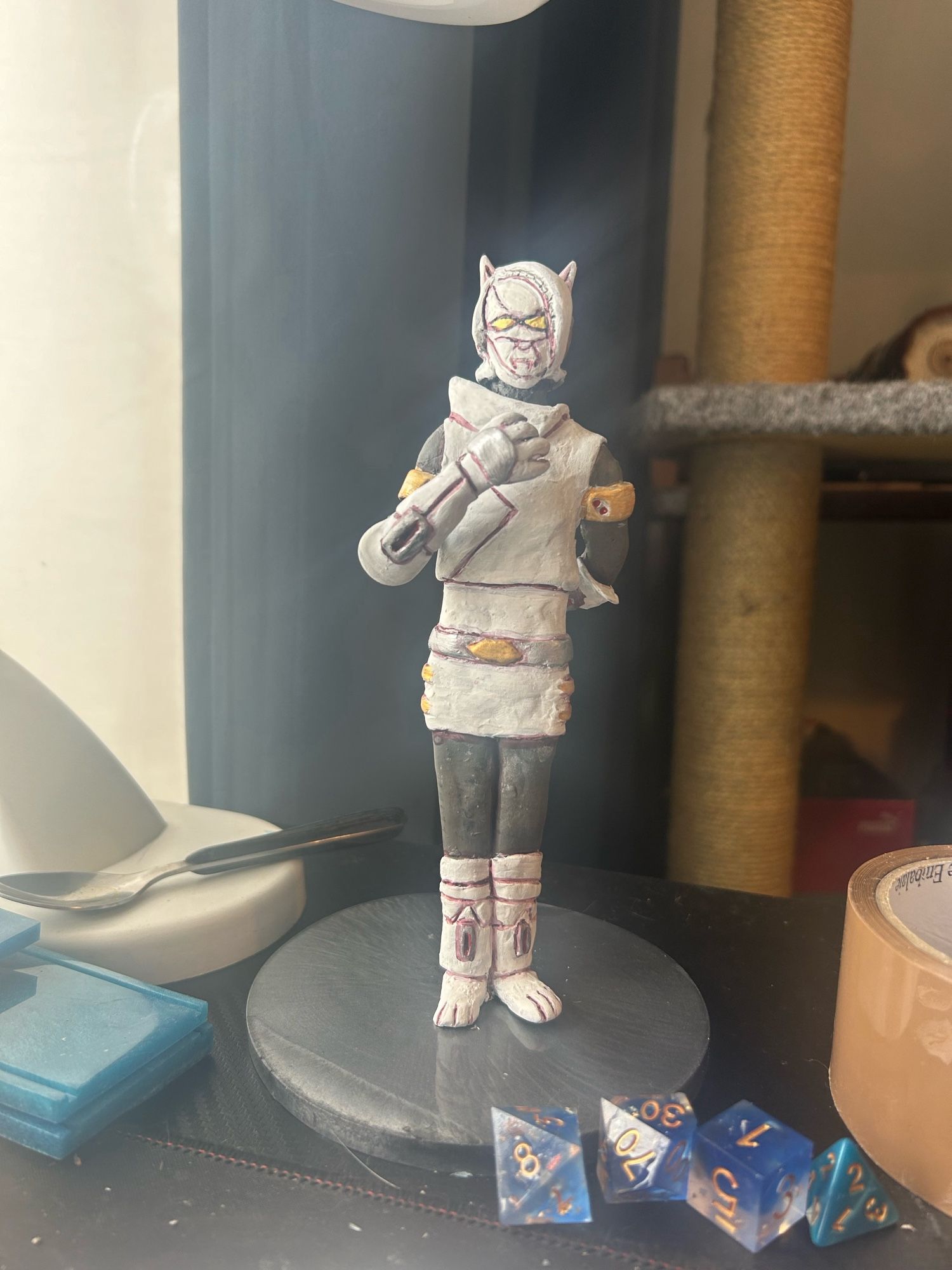 A figurine of an original character in a black base in a black desktop