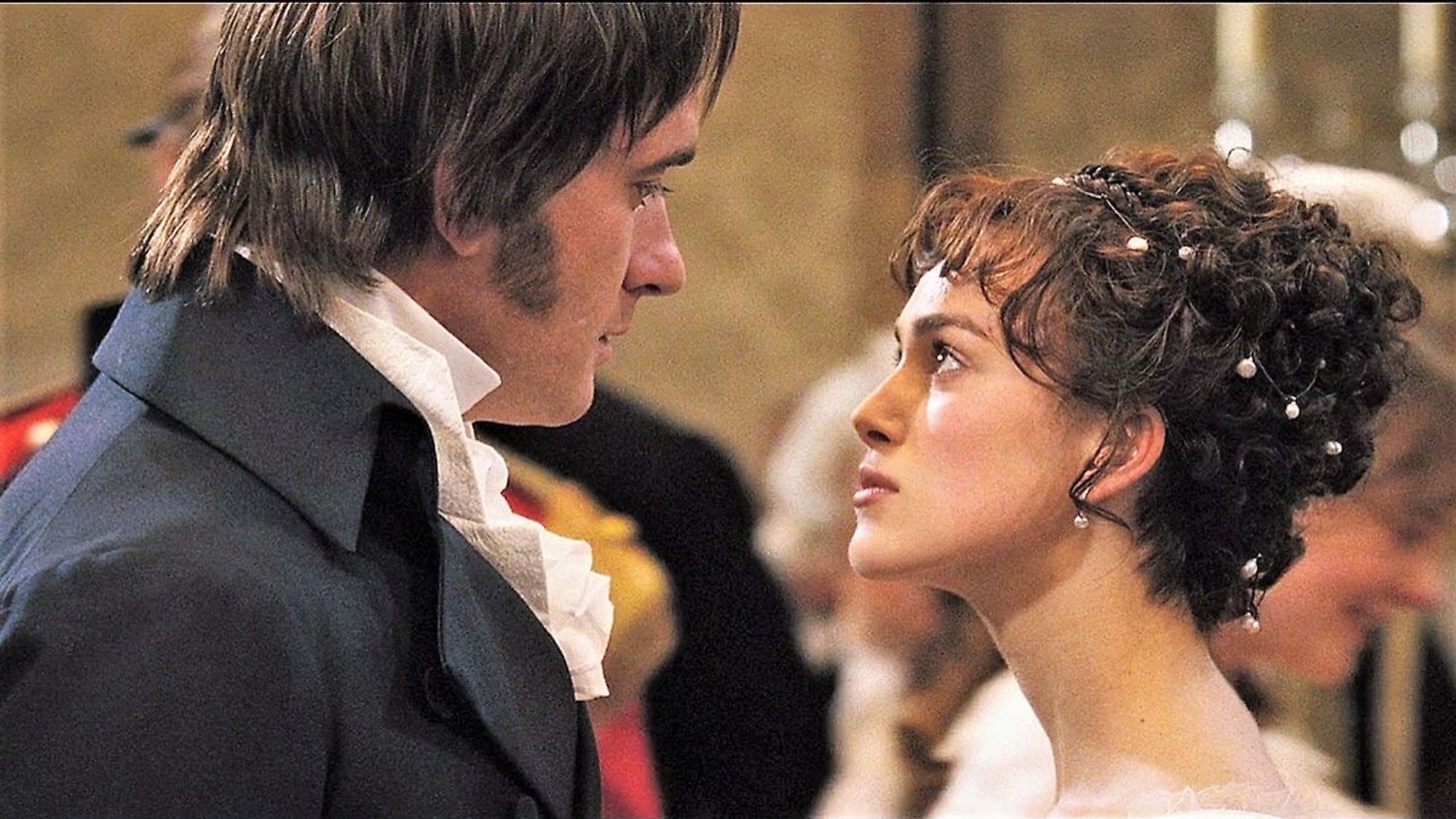 Cena do filme Orgulho e preconceito (2005). Personagens Elizabeth e Darcy se encaram no centro de um baile regencial.