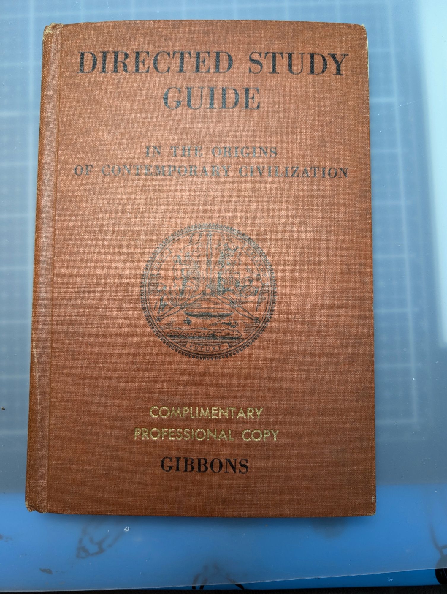 photo of old book: Directed Study Guide in the origins of contemporary civilizations. The cover is a reddish brown cloth hardcover, with black text for the title & some sort of official seal in the middle (also in black). There is a a gold embossed statement: Complimentary Professional Copy above the auther name "Gibbons"