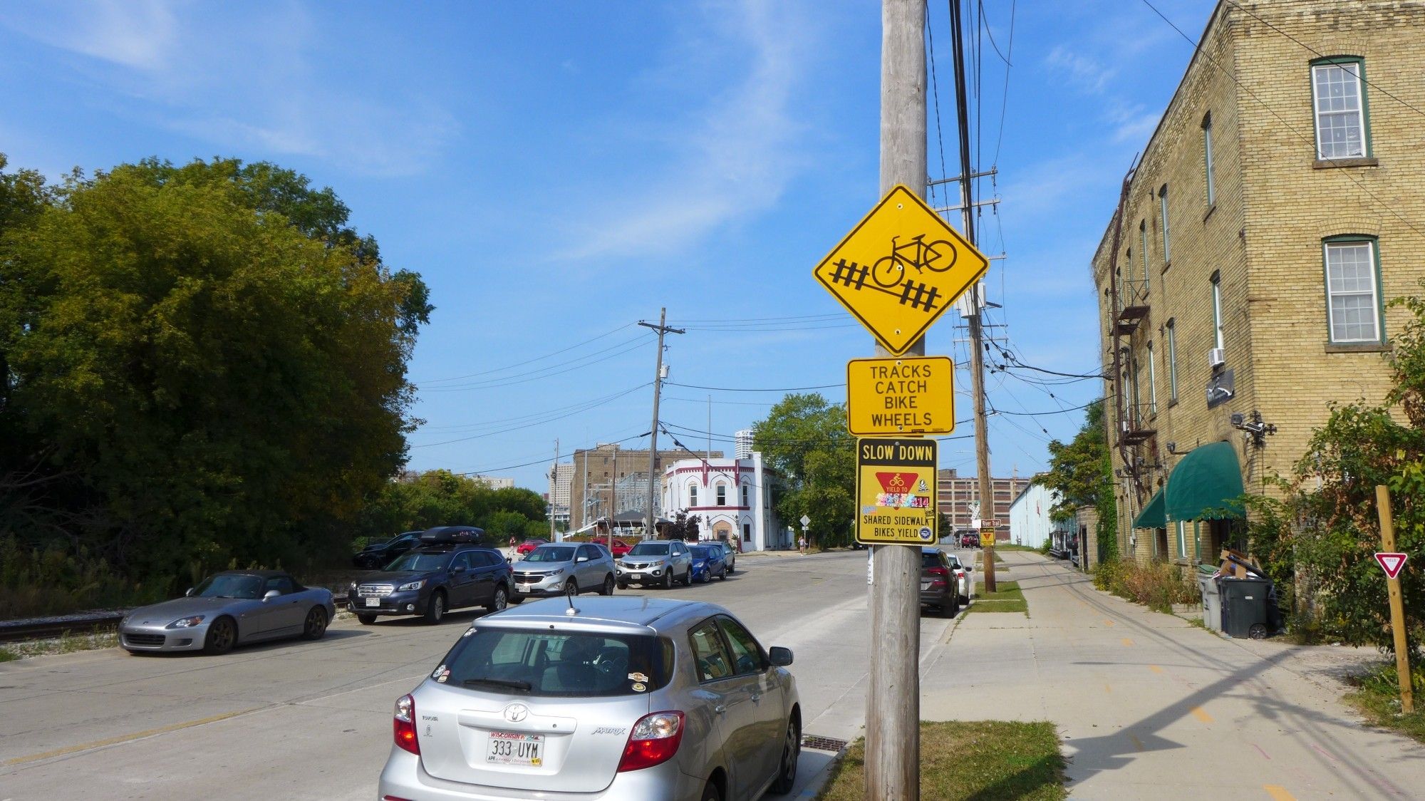 Street photo showing warning signs about train tracks catching bike wheels.