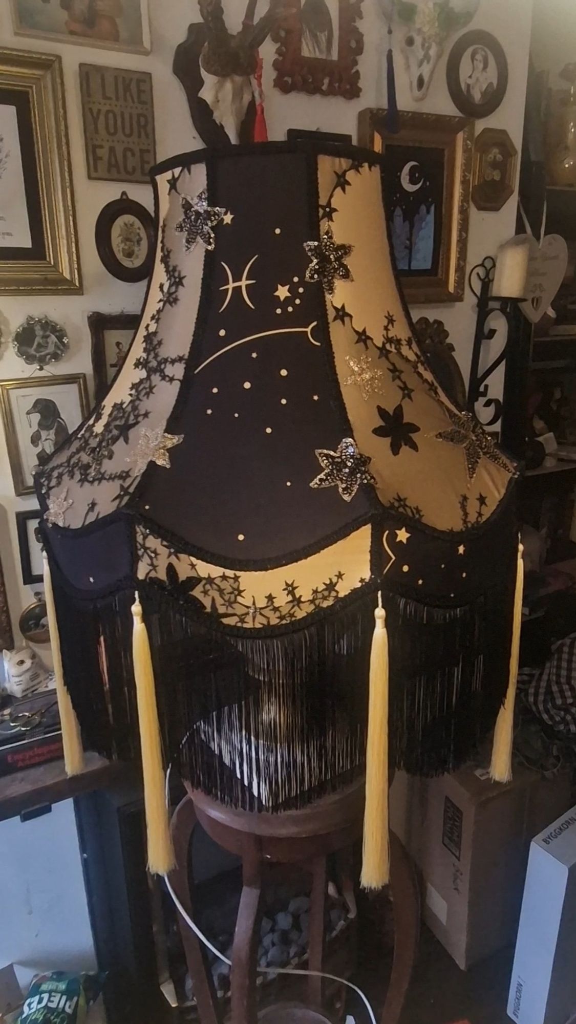 A black and gold lampshade with sequin stars