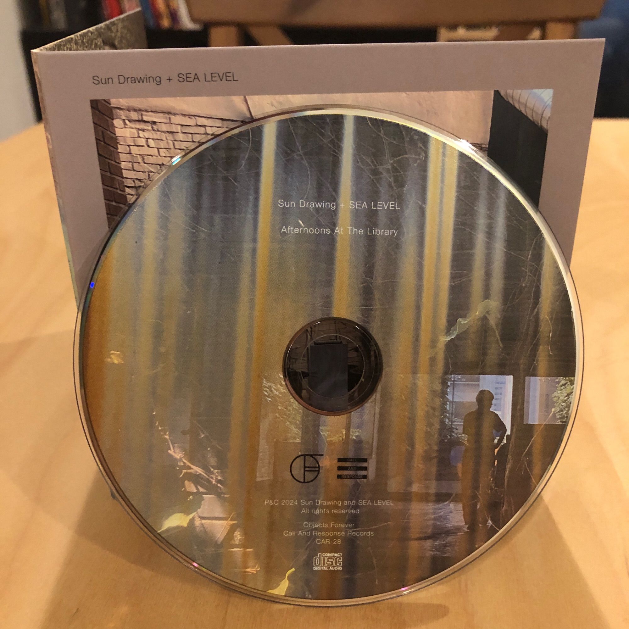 The Sun Drawing + Sea Level album “Afternoons At The Library” CD jacket from the front with the CD itself