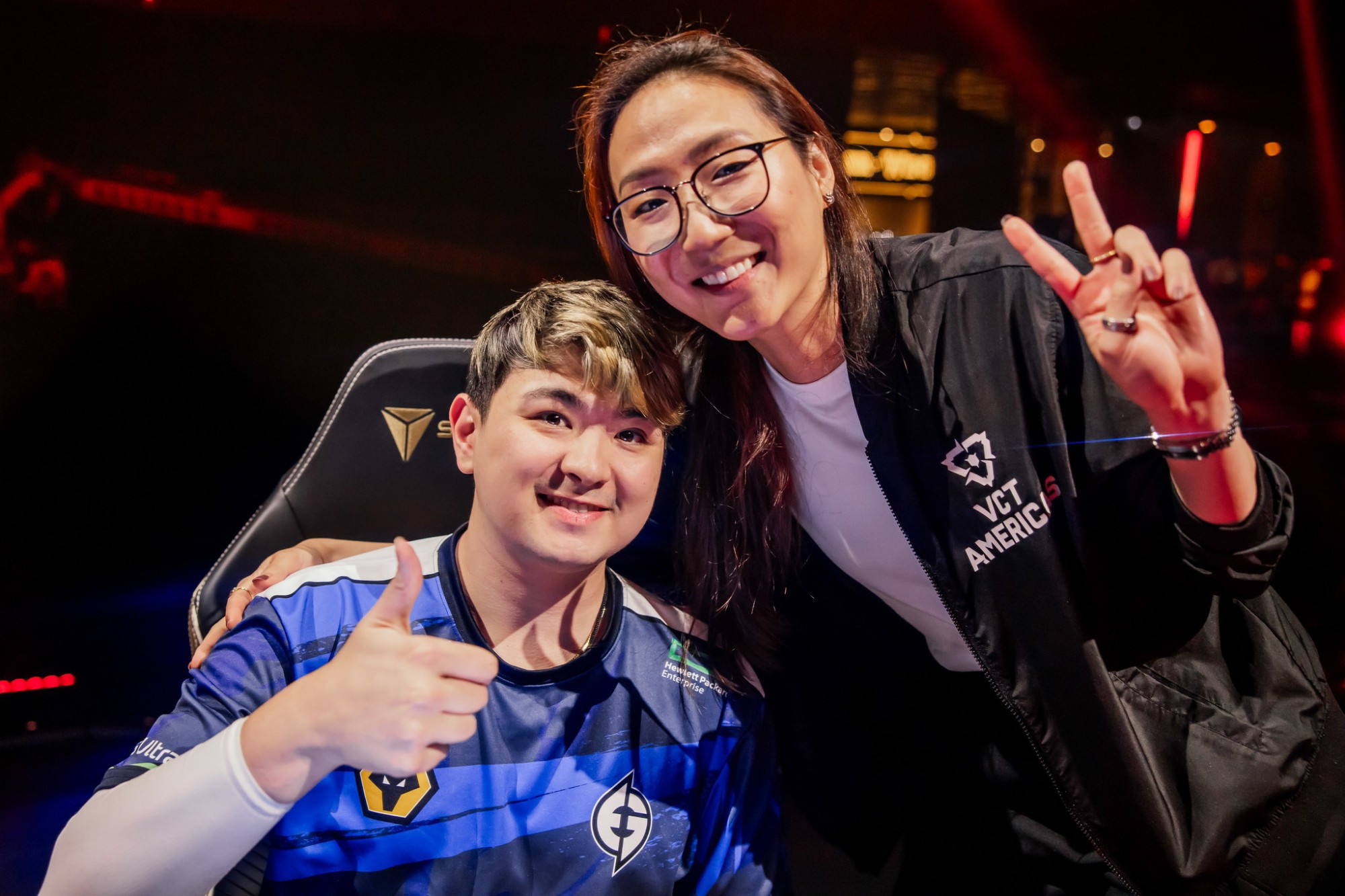 A picture of Evil Geniuses VALORANT player, C0M (left), doing a thumbs up and Evil Geniuses' Head Coach, Potter (right), doing the peace sign.