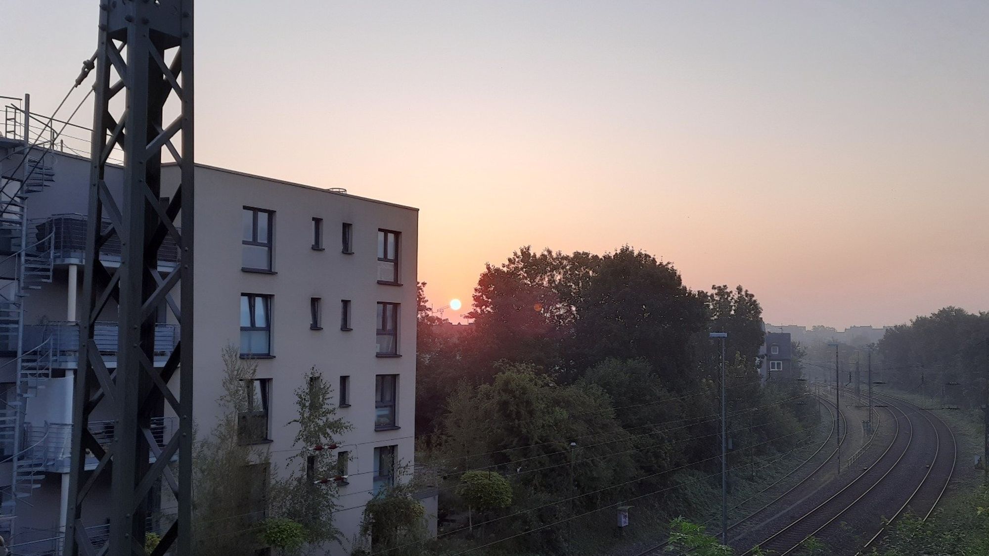 Sonnenaufgang mit roter Sonne über der Stadt 