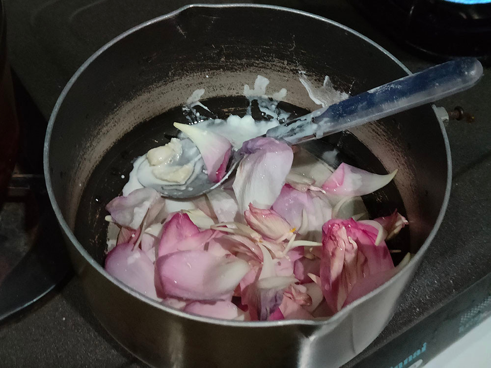 pink lotus petals in batter in a sauce pan