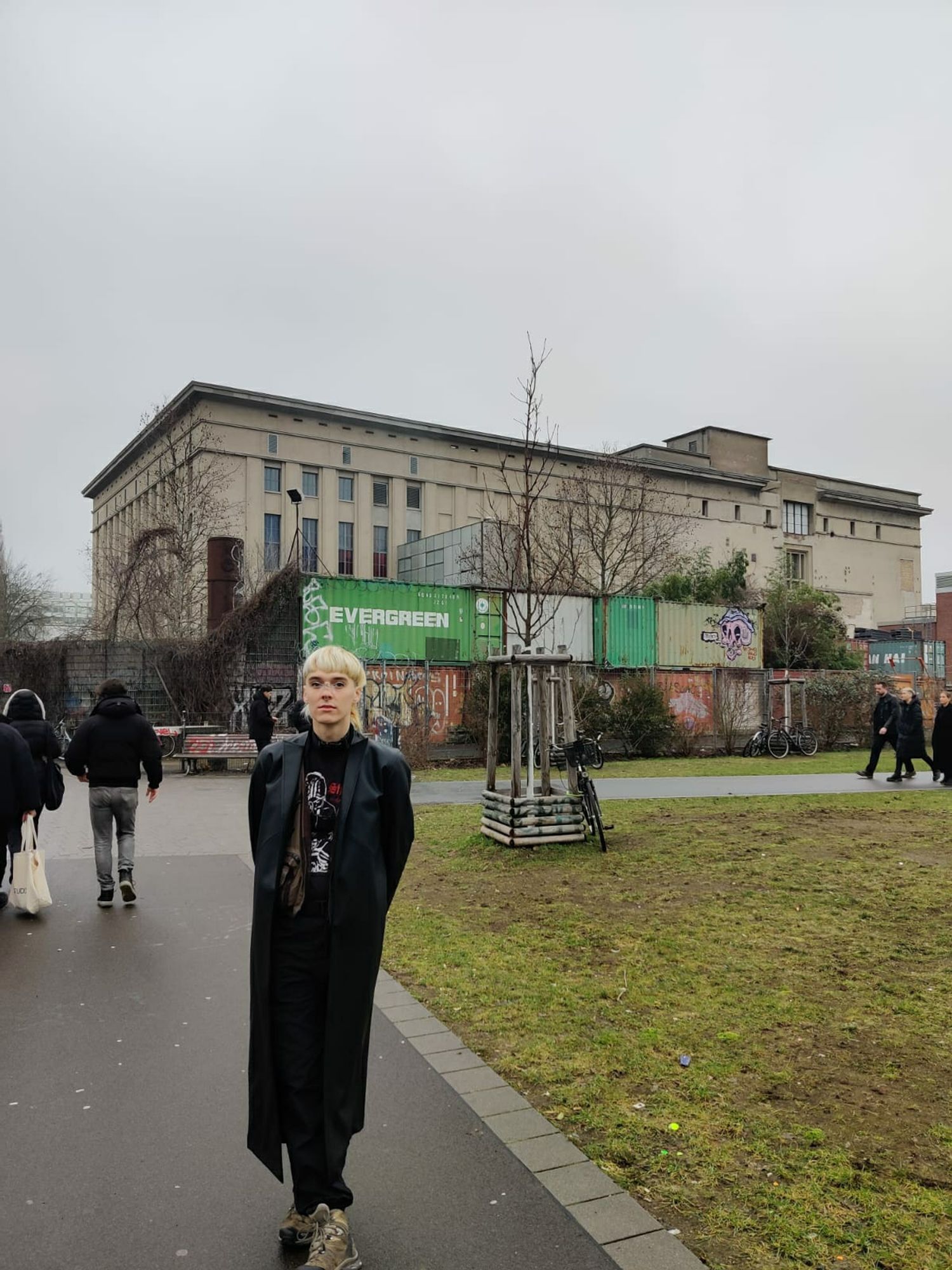 Trans dyke in a leather trench outside berghain