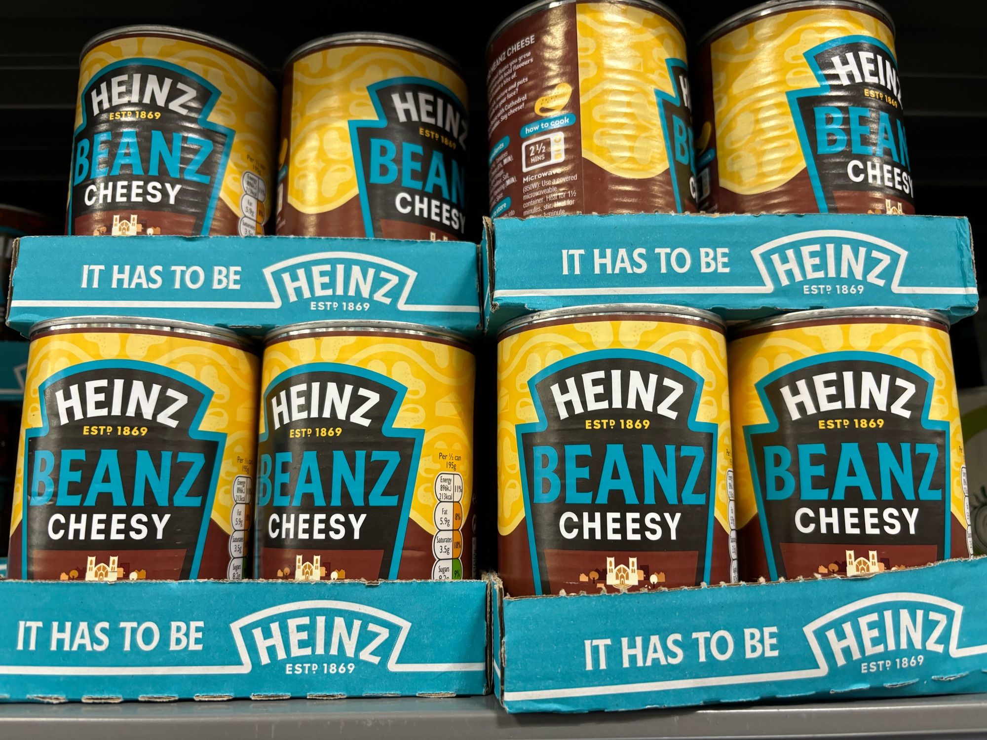 Row of cans of Heinz Beanz Cheesy