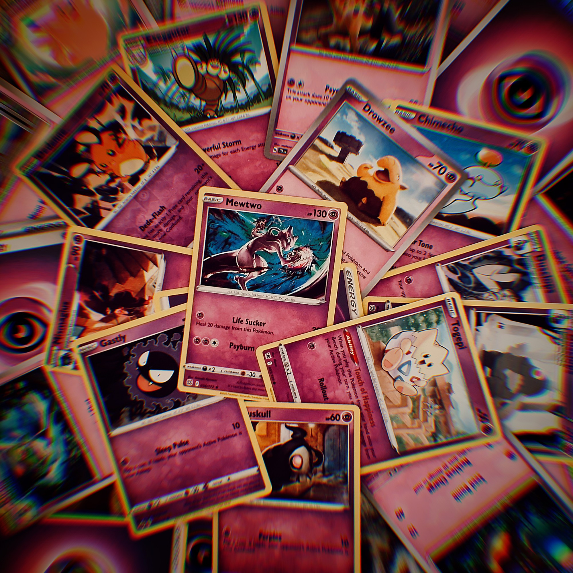 A bunch of psychic type pokemkn cards scrambled. With a vintage filter over the picture