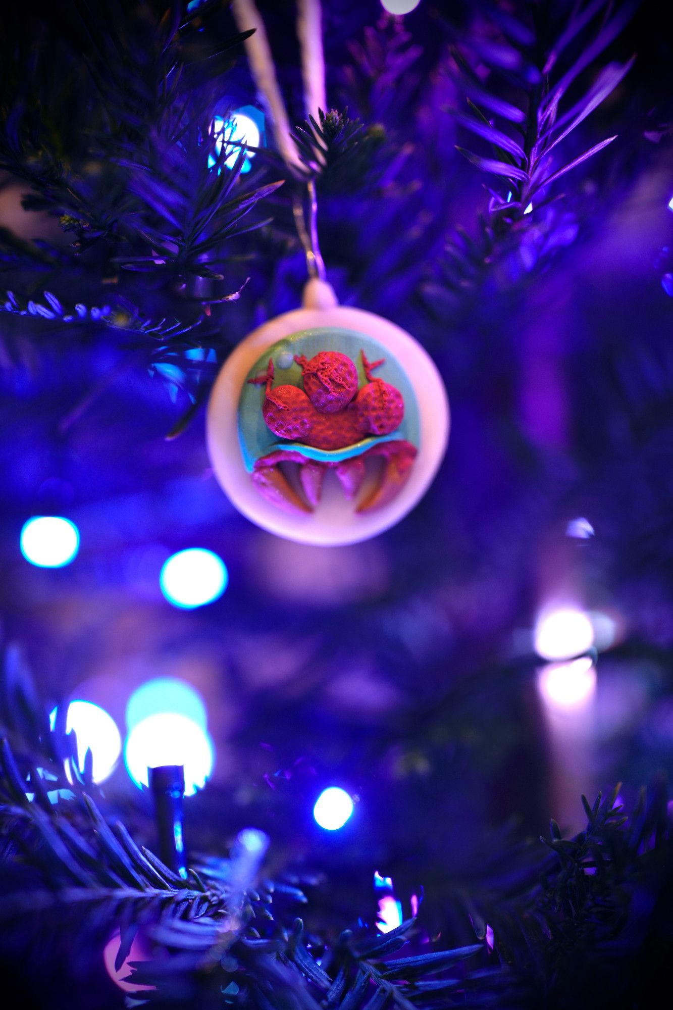 Metroid ornament on a christmas tree. The ornament background glows after light exposure!