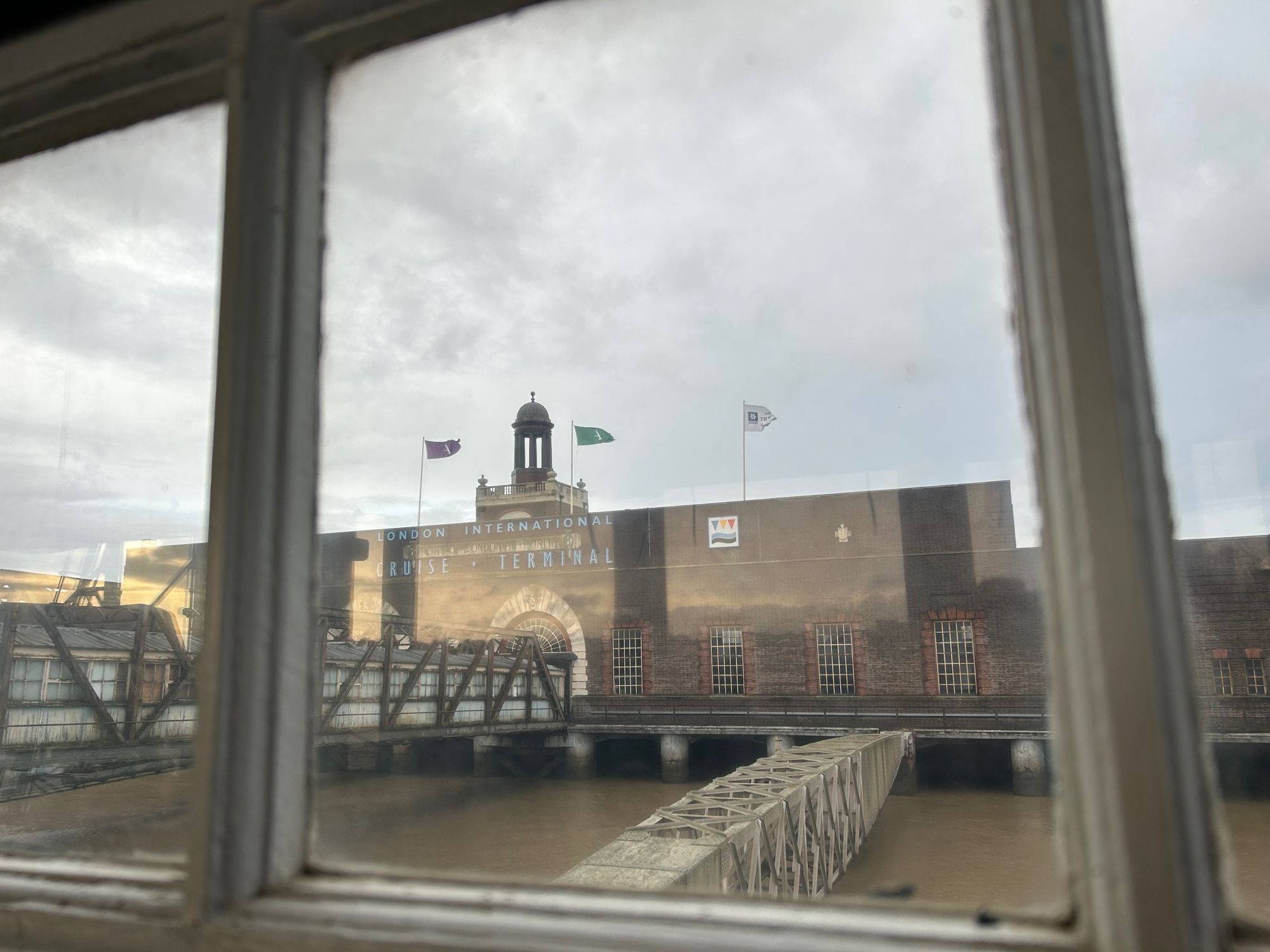 View from the river back at the terminal - a large brick building with struts out where the boats docked