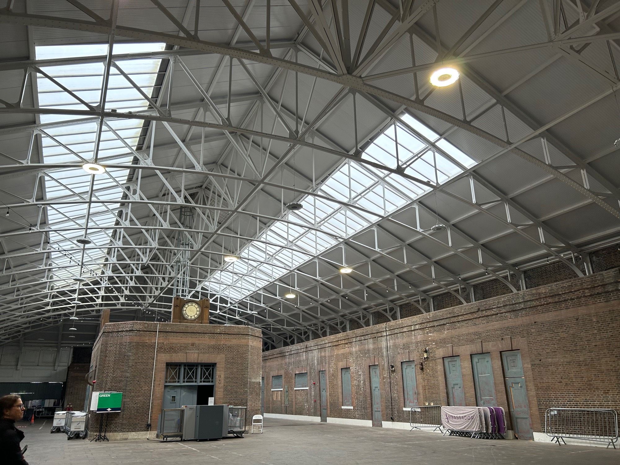 The central building of the terminal - a large space, with steel structure roof, 1930s brickwork ticket office in the middle and along the side red brick with door says