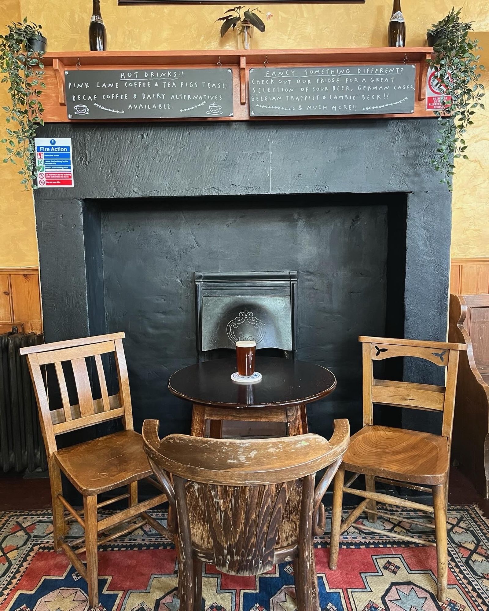 Fireplace, table, chairs and a half of cask bitter at The Free Trade Inn