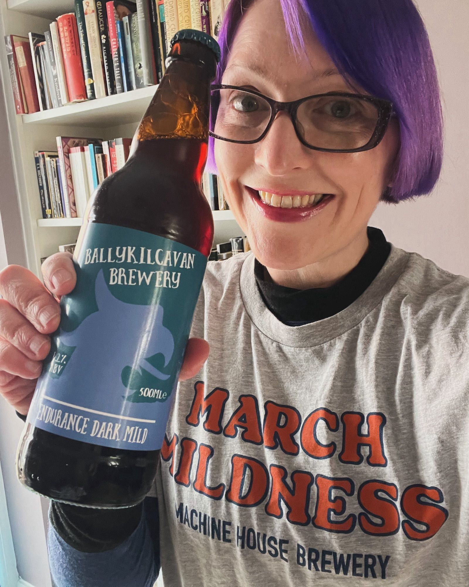 Pale white lady in Machine House Brewery March Mildness t-shirt with a bottle of Ballykilcavan Endurance Dark Mild