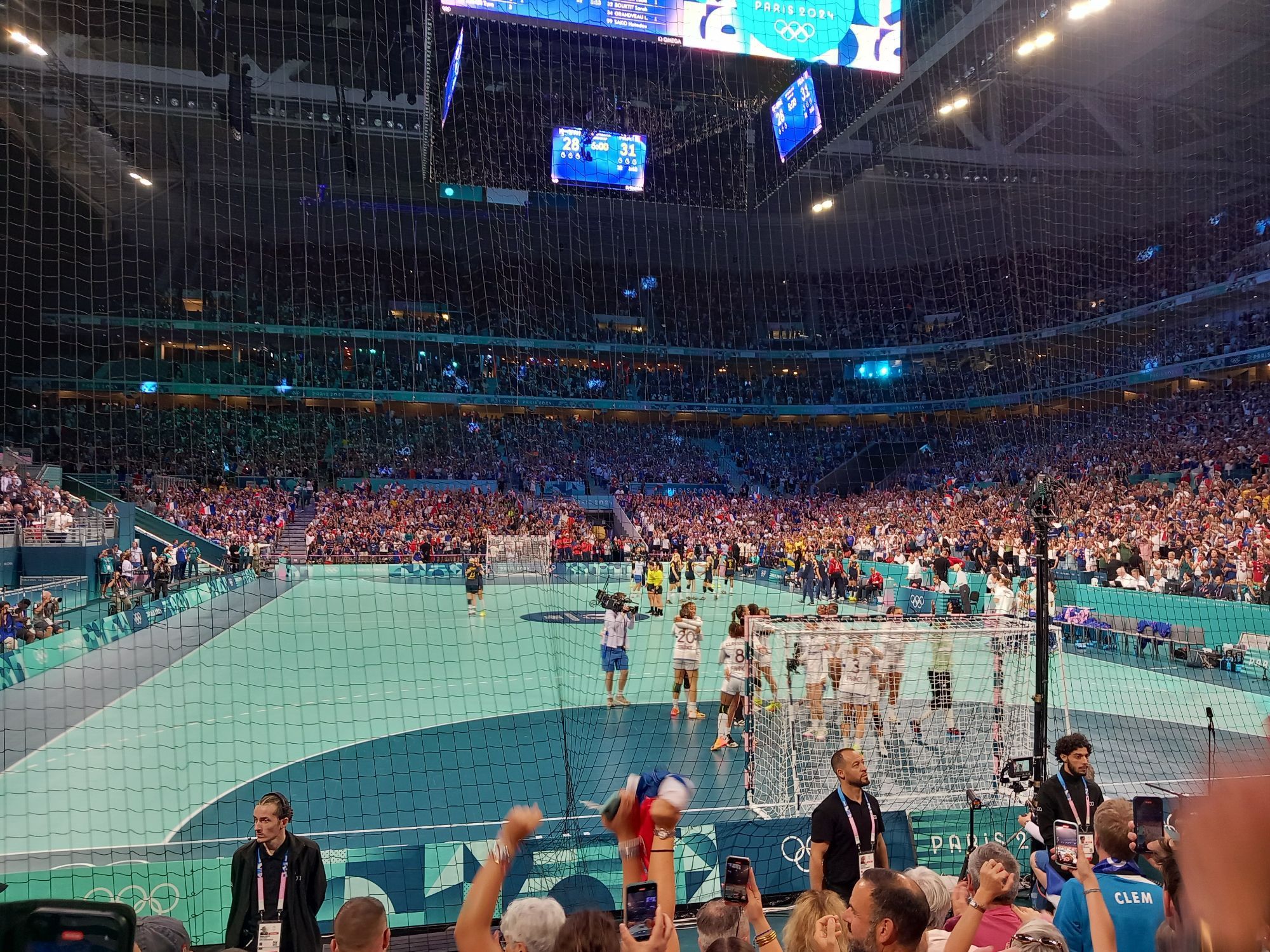 Célébration de l'équipe de France de handball, vue de derrière les buts