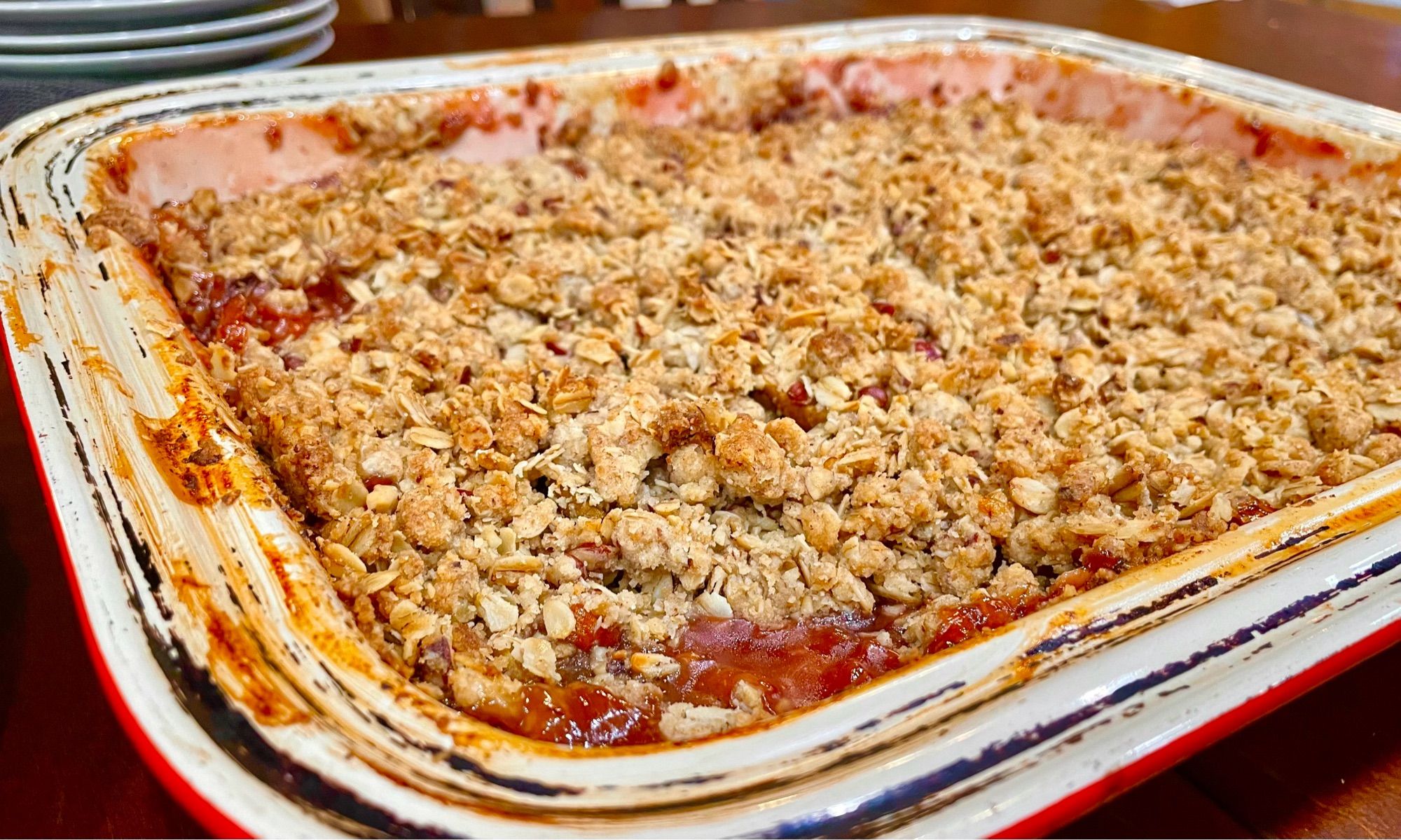 Not technically a pie, but a crusty baked crumble in cream rimmed rectangular baking dish. The crumble topping is toasty brown with oat flakes and pecan pieces poking out. The jeweled red filling is bubbling up from underneath. It’s a mix of pears, apples, cranberries with ginger, cardamom and clove spices mixed in