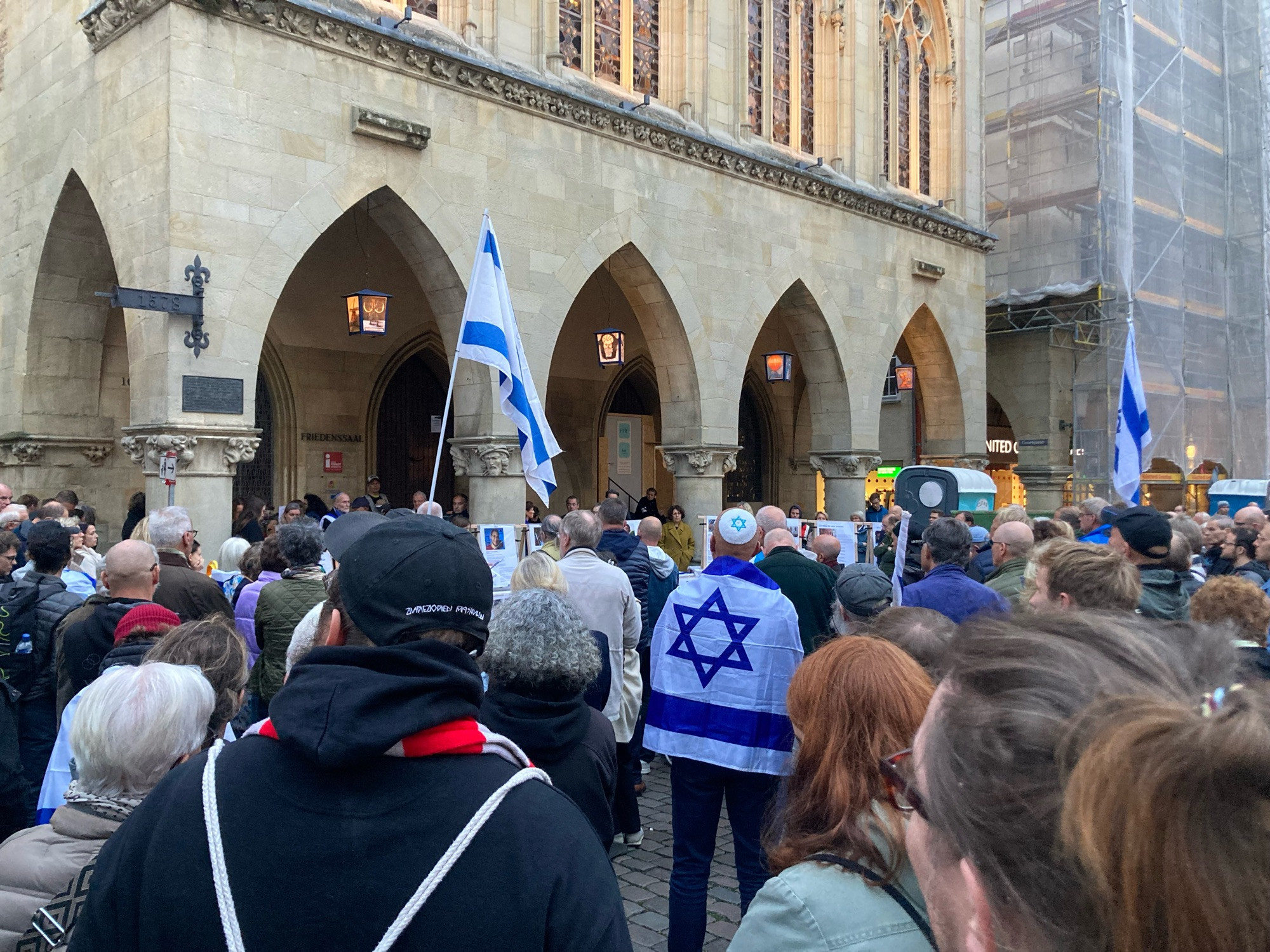 Menschen vor dem historischen Rathaus in Münster, die der Opfer des 7. Oktober gedenken.