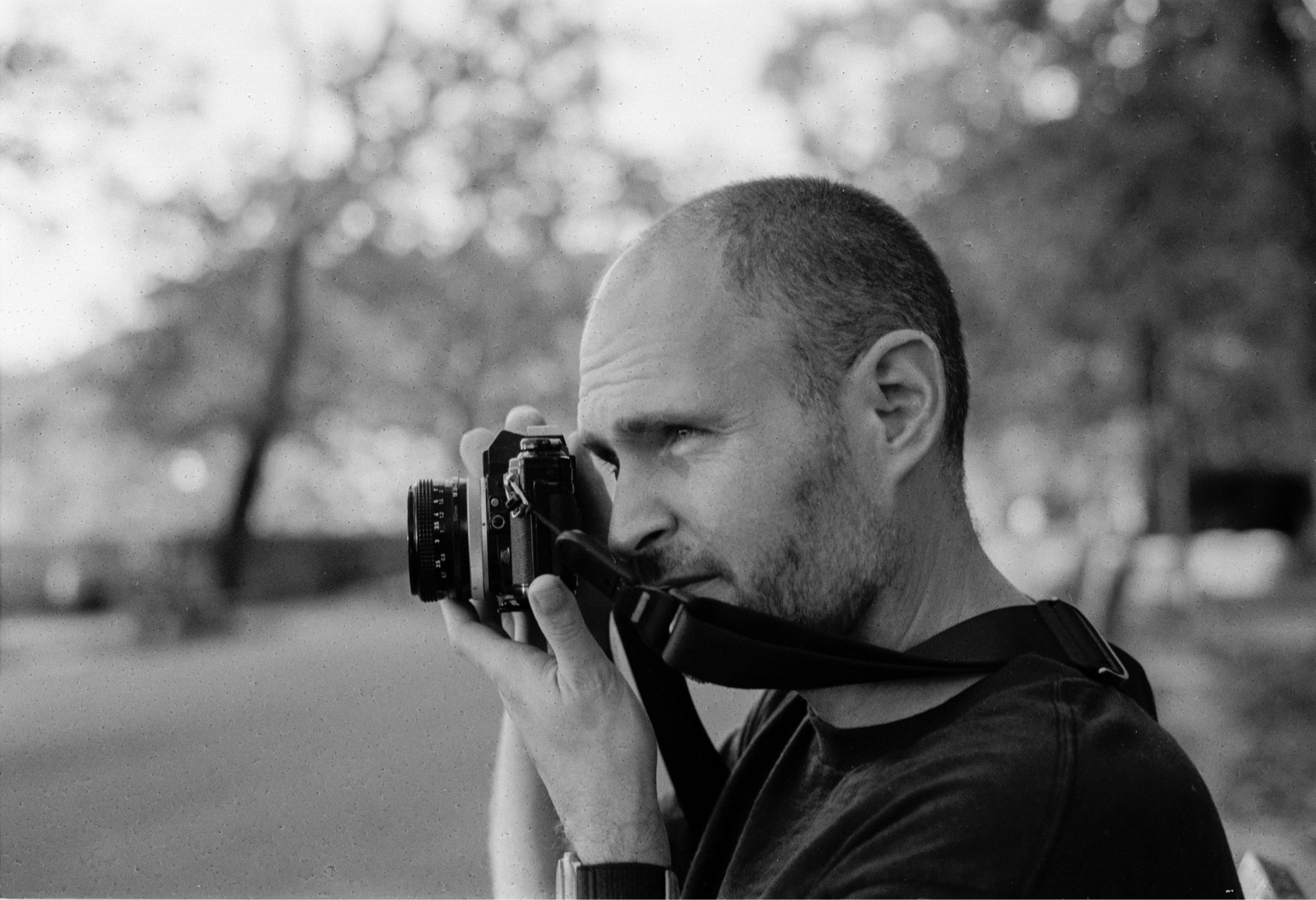 Photo of me holding a camera in black and white.