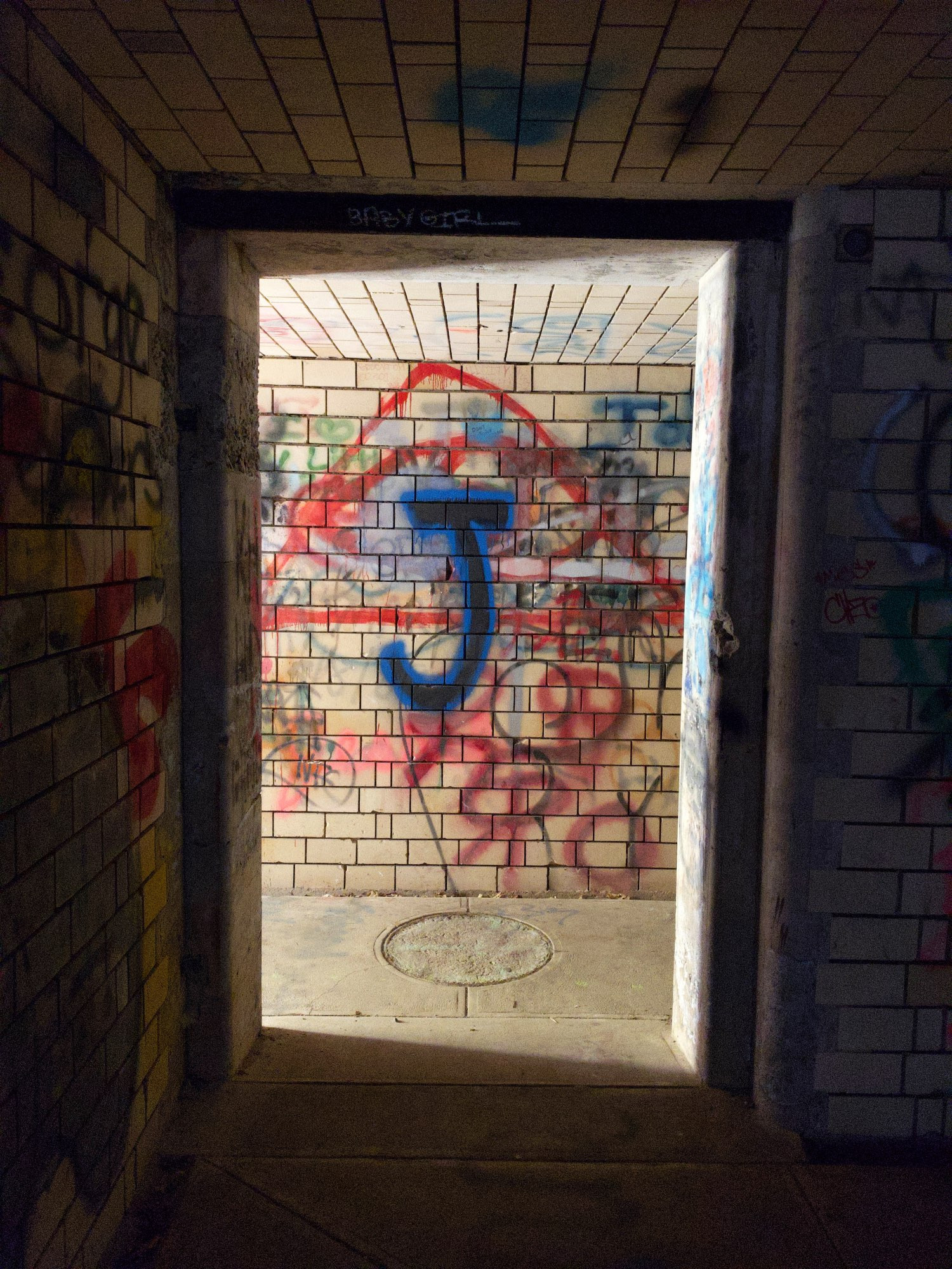 An abandoned hallway, covered in graffiti.