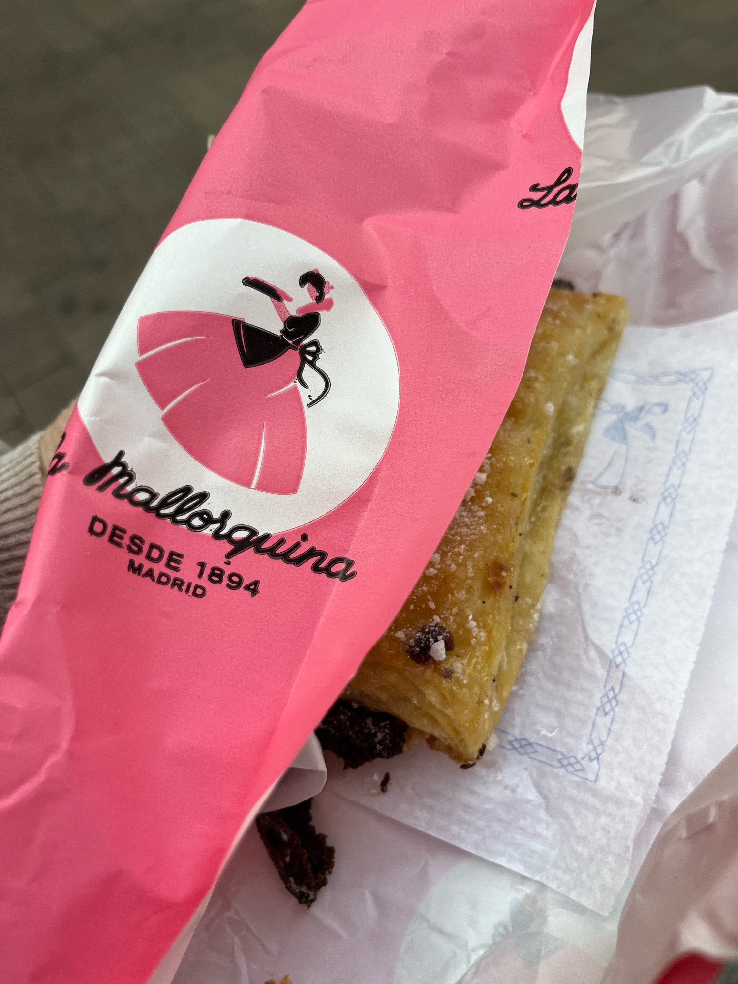 Chocolate pastry in pink wrapper that says La Mallorquina Desde 1894 Madrid