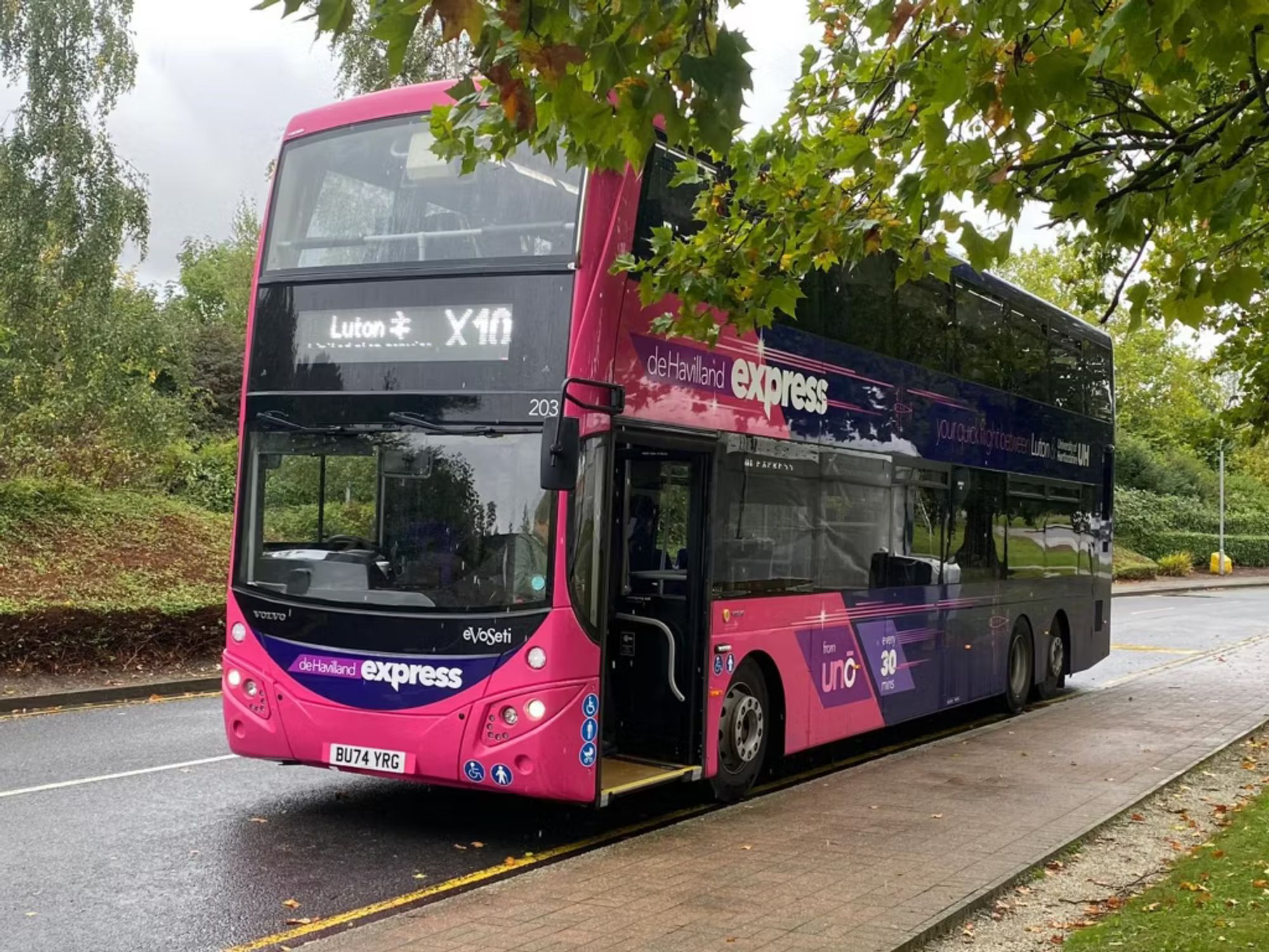 A pink and blue double-decker bus parked at a stop, with "X10" and "Luton" on the destination board.

Photo by Volvo