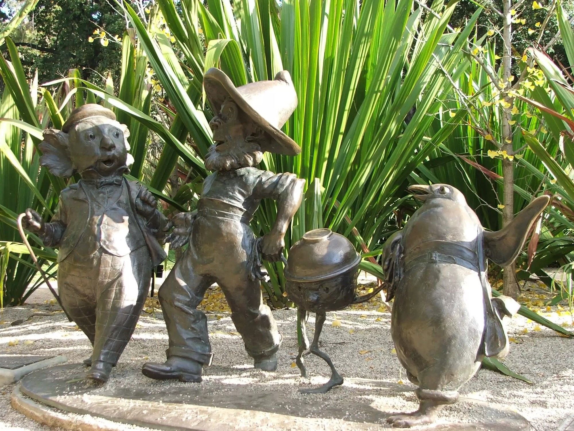 Four characters cast in bronze. Characters are child-height and surrounded by plants. They are holding hands (and flippers).