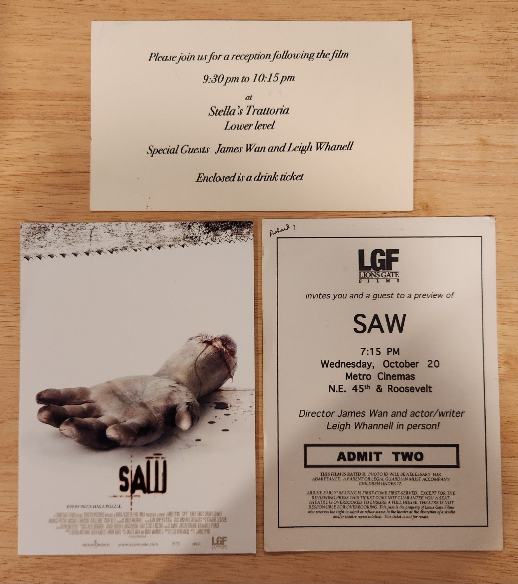 A photograph of a promo cardstock poster, press invite, and drink ticket for an advance screening of the original Saw (2004), in Seattle on Wednesday, October 20th, 2004, with a Q&A and reception with co-writer/director James Wan and co-writer/actor Leigh Whannell in attendance.