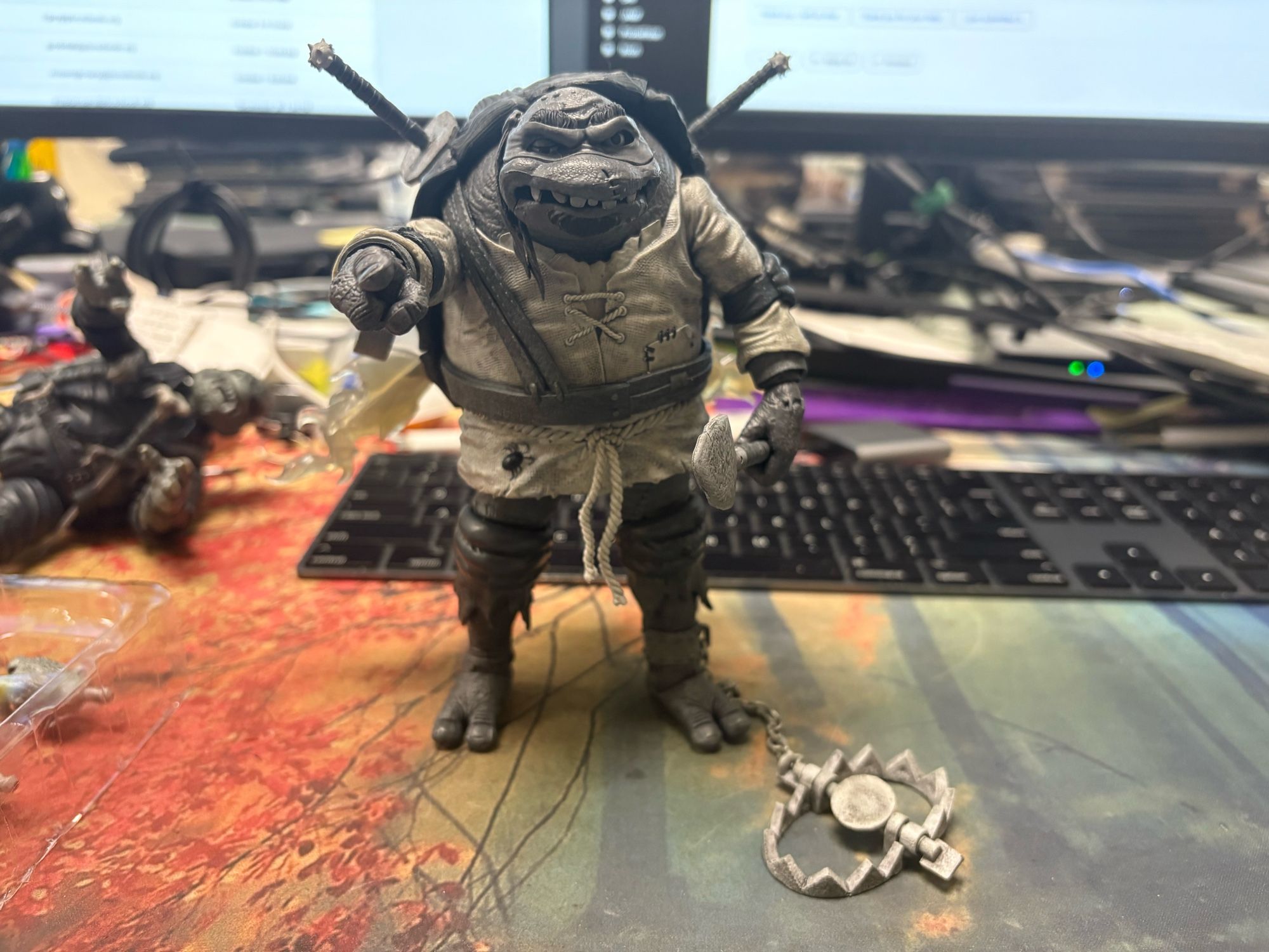 Universal Monsters x TMNT Hunchback Leonard from the front, holding a shovel in his left hand and pointing at the camera. Bear trap on the floor next to him.