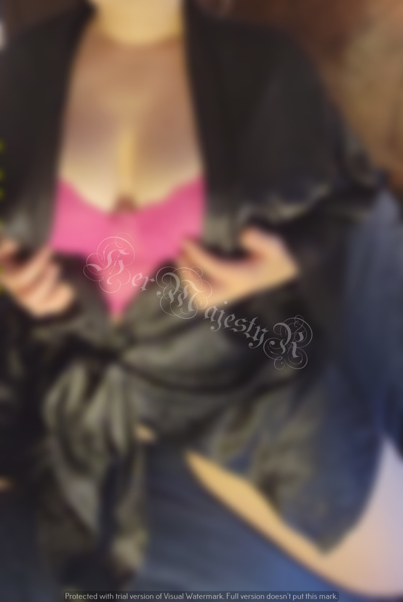 a blurred photo of a woman in a black silk robe and a pink lace bra exposed.