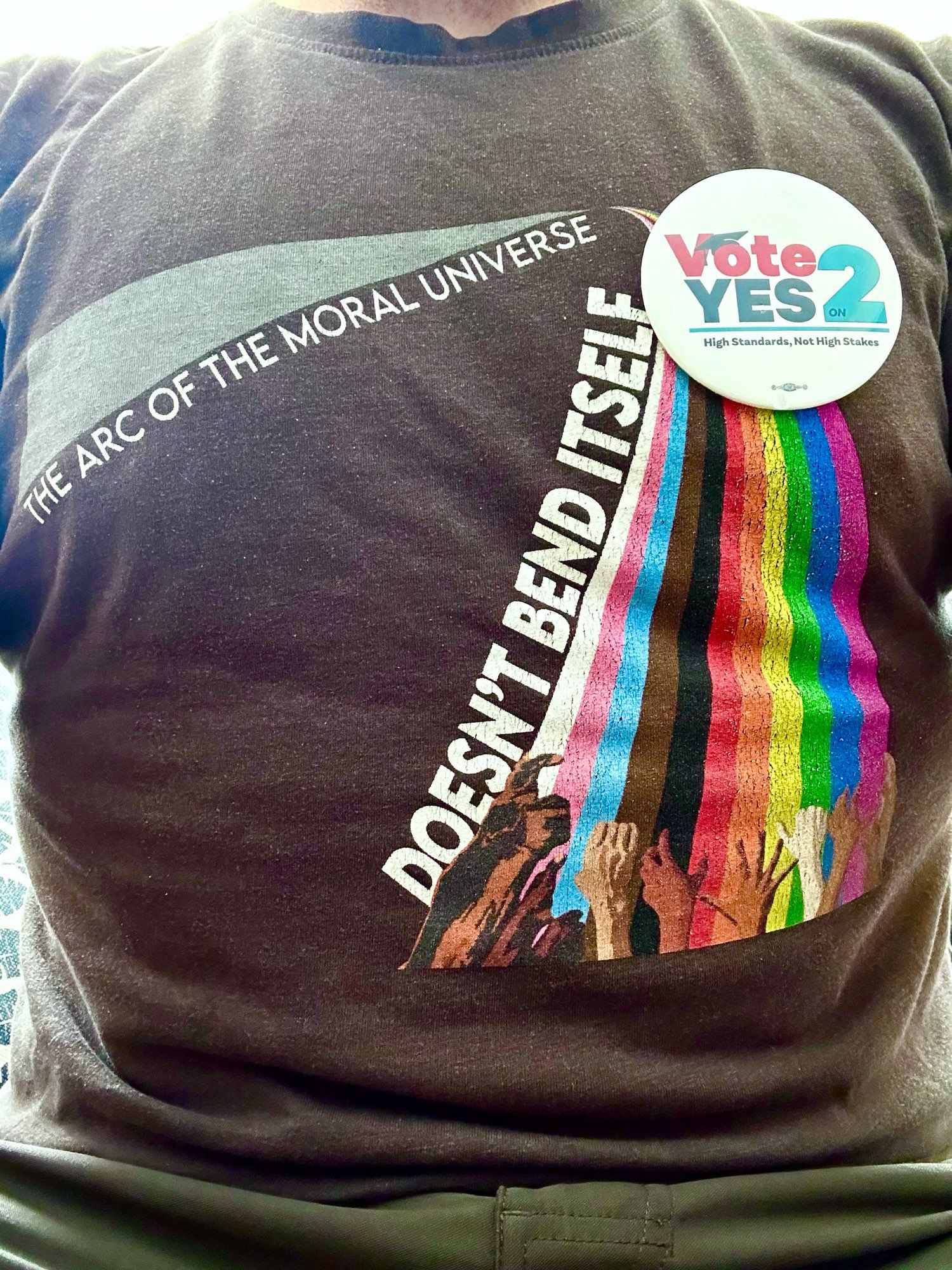 Vote Yes on 2 button pinned to a t shirt that reads “the arc of the moral universe doesn’t bend itself.”