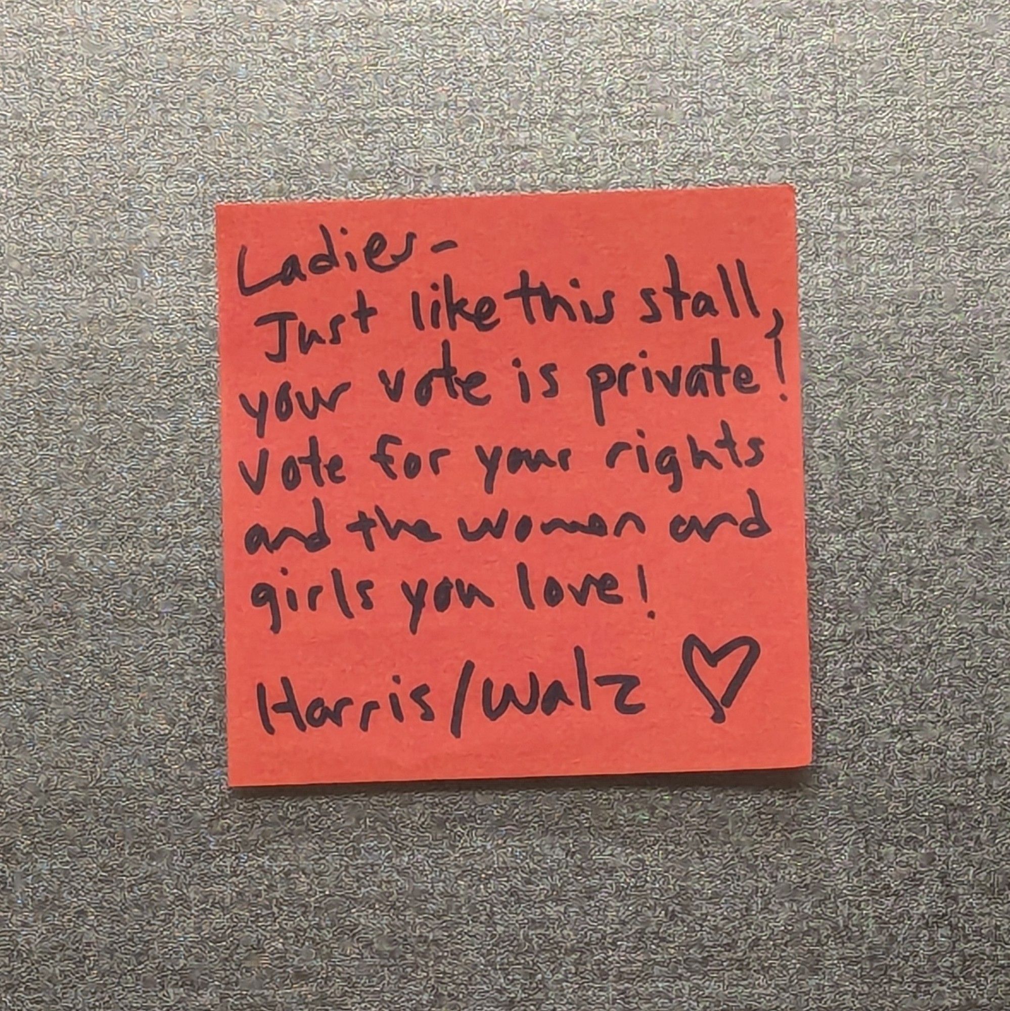 Red Post-it note: Ladies, Just like this stall, your vote is private! Vote for your rights and the women and girls you love! Harris/Walz ❤️