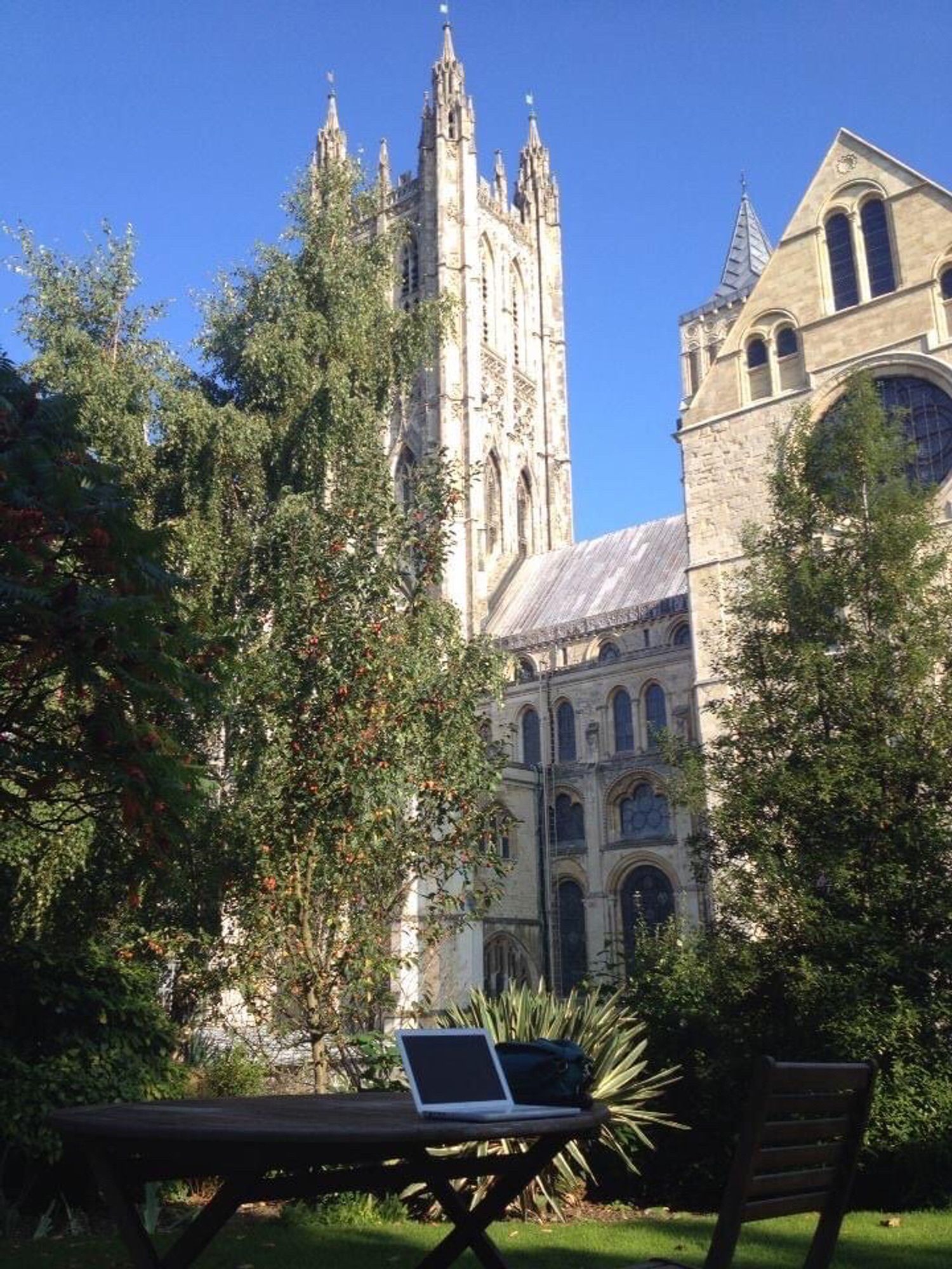 Canterbury Cathedral in the background of the Lodge garden, where my laptop is on a table.