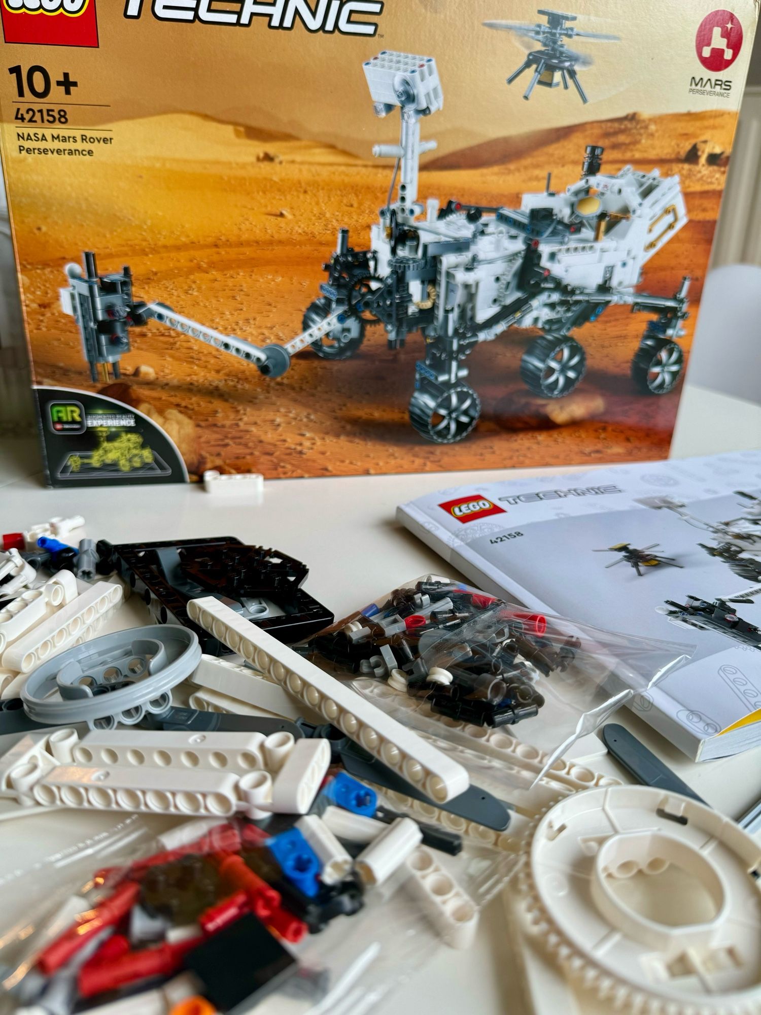 Foto der Lego-Technik Box des NASA Mars Rover Perseverance, davor die ersten Teile und die Anleitung.