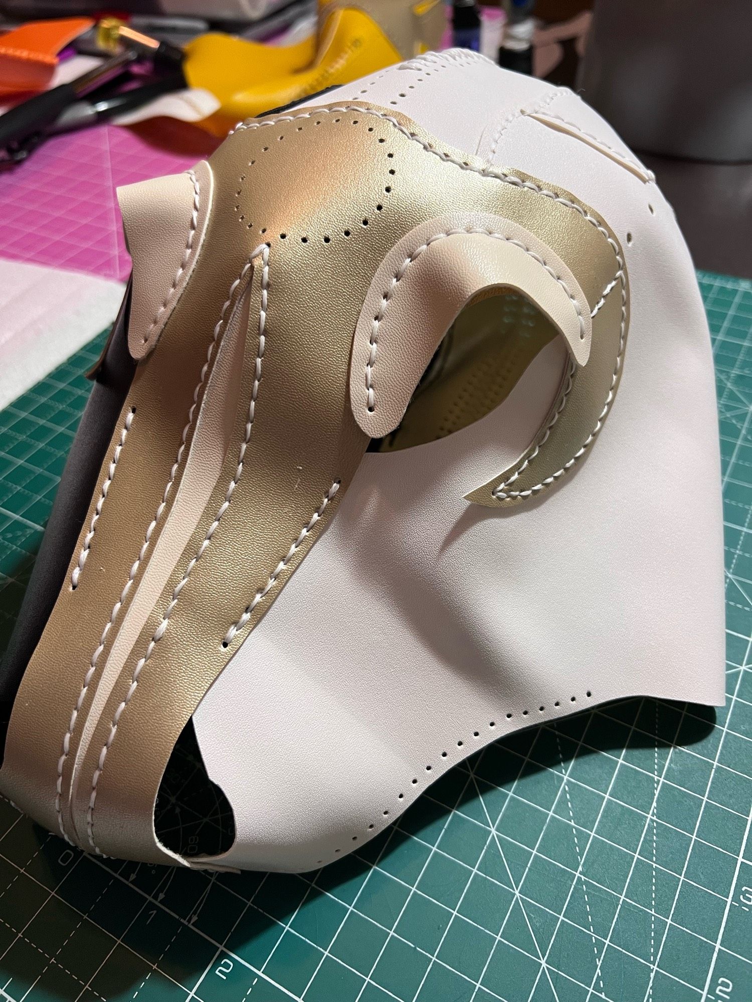 A half finished pony/unicorn hood in white black and gold.