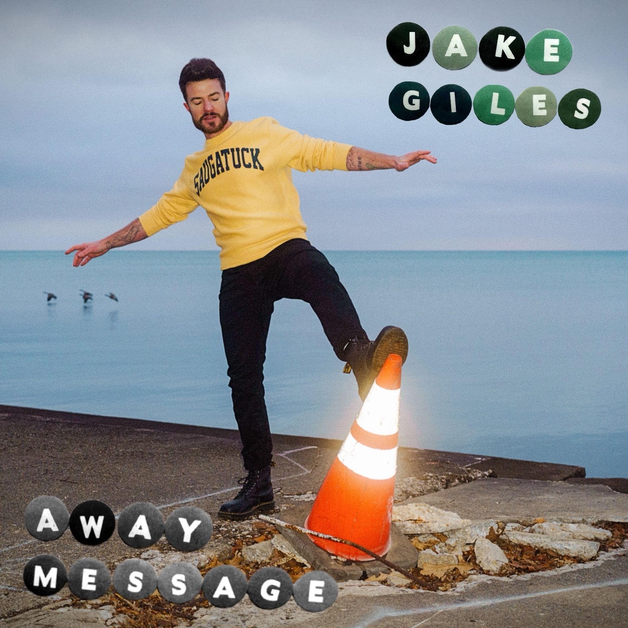 cover image of my EP called Away Message. I’m wearing a yellow sweater with the word Saugatuck on it, balancing on an orange traffic cone.